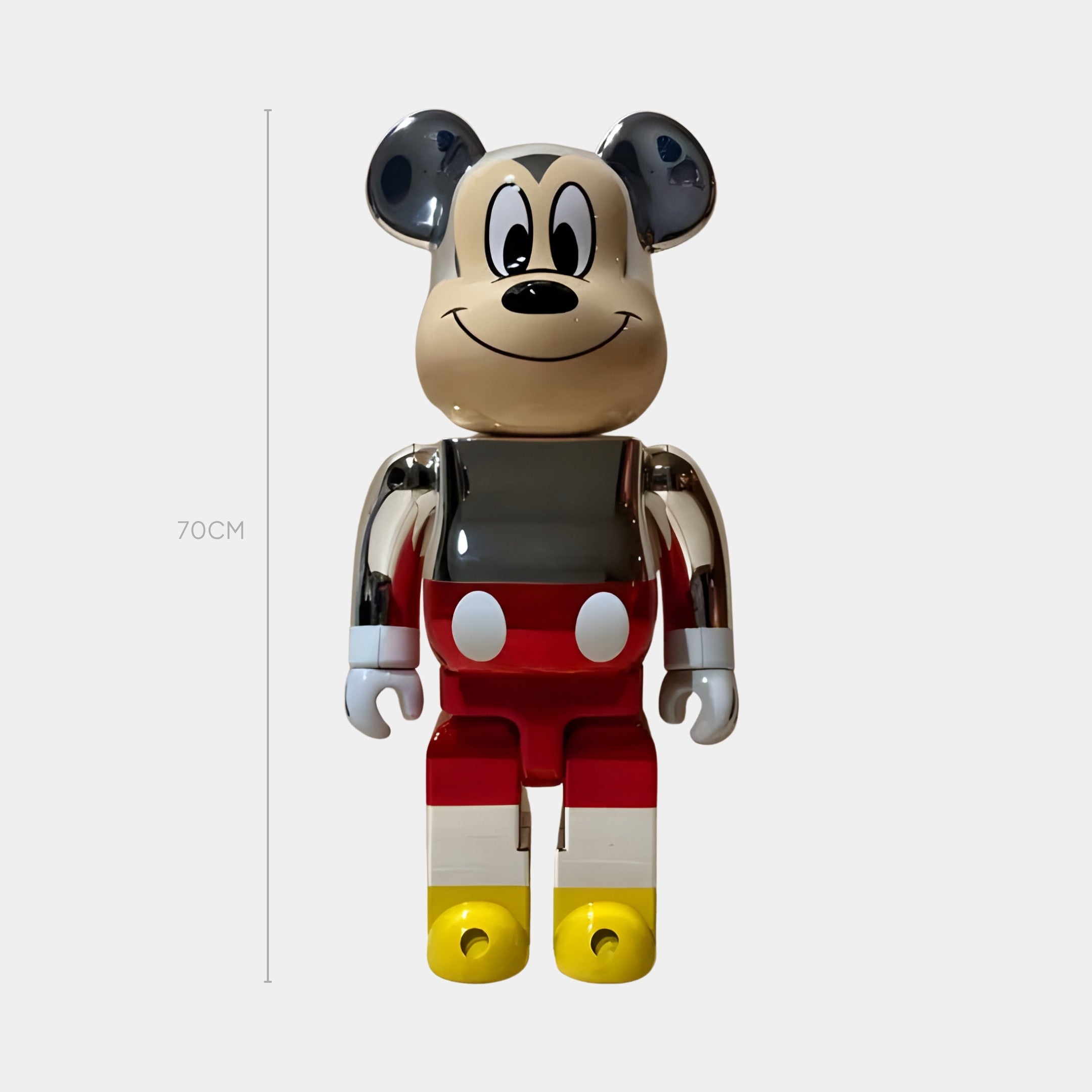 The Retro Chrome Toon Bear Sculpture by Giant Sculptures stands 70cm tall, featuring a gray, black, red, yellow, and white palette with a nostalgic animation vibe—smiling and upright against a plain light background.