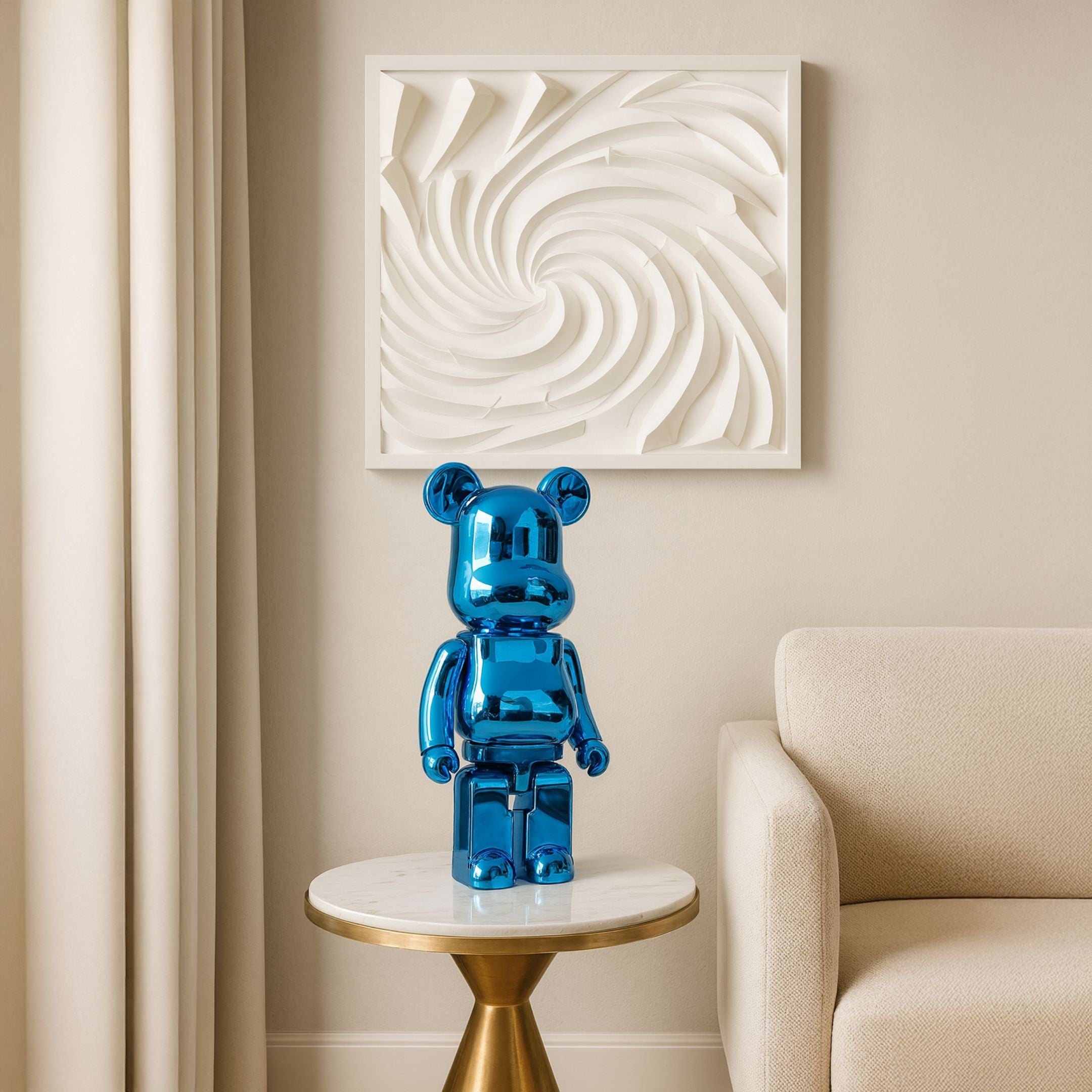 Sapphire Blue Bear Sculpture, 50cm, in electroplated blue resin on a marble side table beside a beige sofa, with abstract white wall art above.