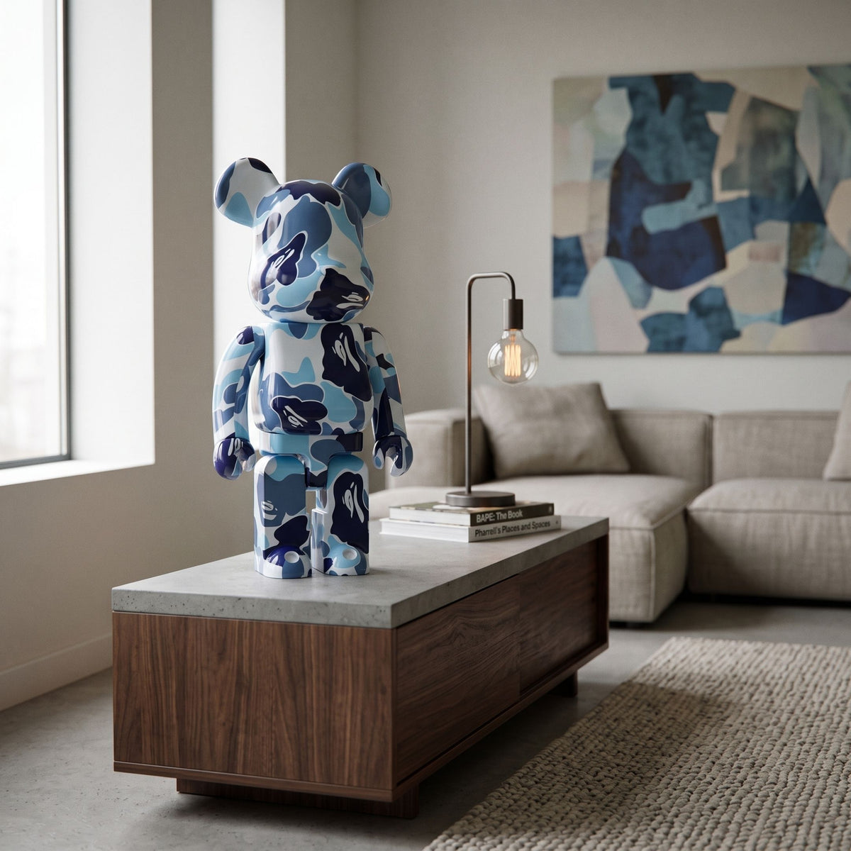 Sapphire Drift Bear Sculpture - 70cm in glossy blue camouflage resin, displayed on a coffee table in a living room with a grey sofa and framed wall art.