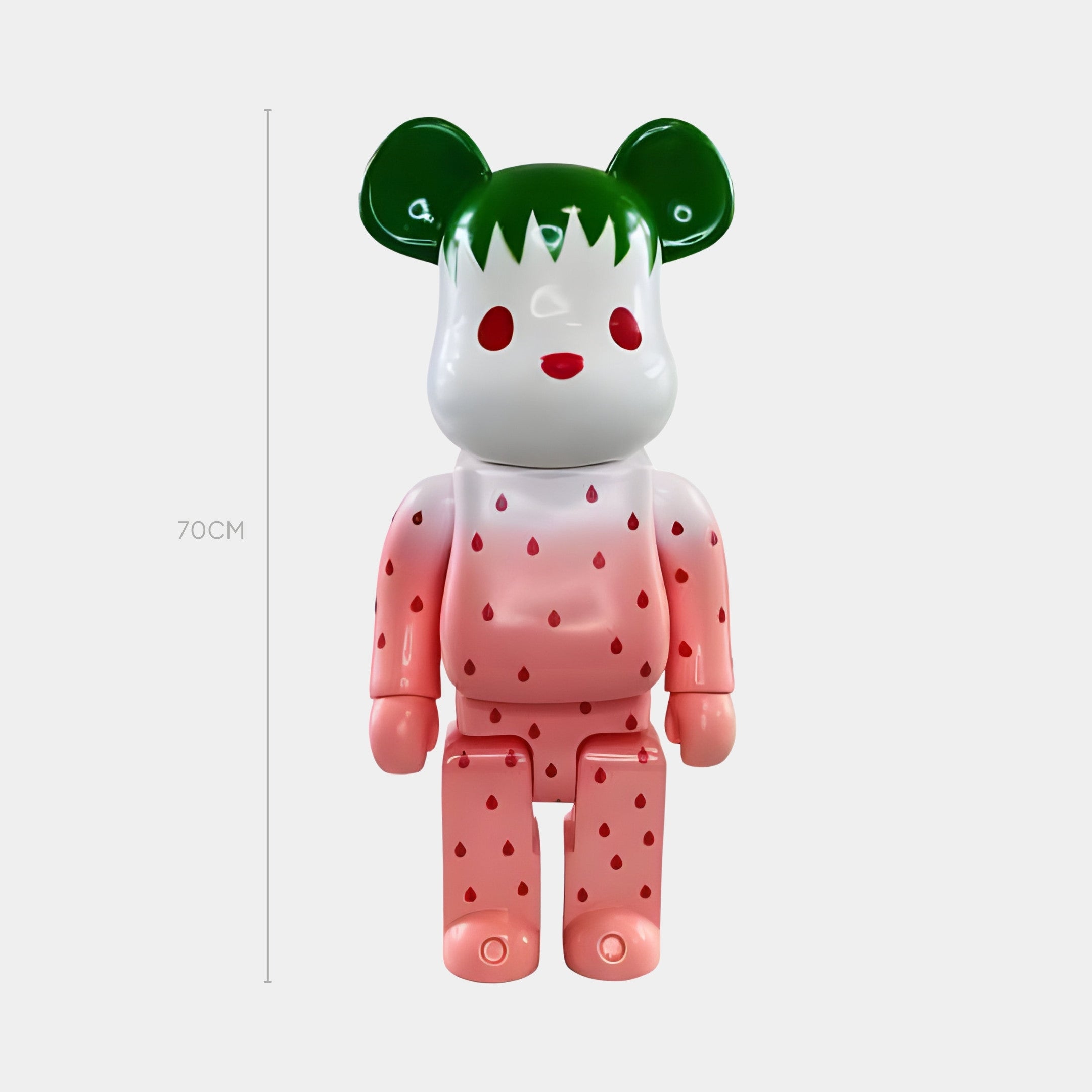 The Giant Sculptures Seeded Gradient Bear Sculpture - 70cm features a bear-shaped head, green ears and hair, red dot eyes, a white face, and a pink body with strawberry seed-like dots—crafted in modern resin.