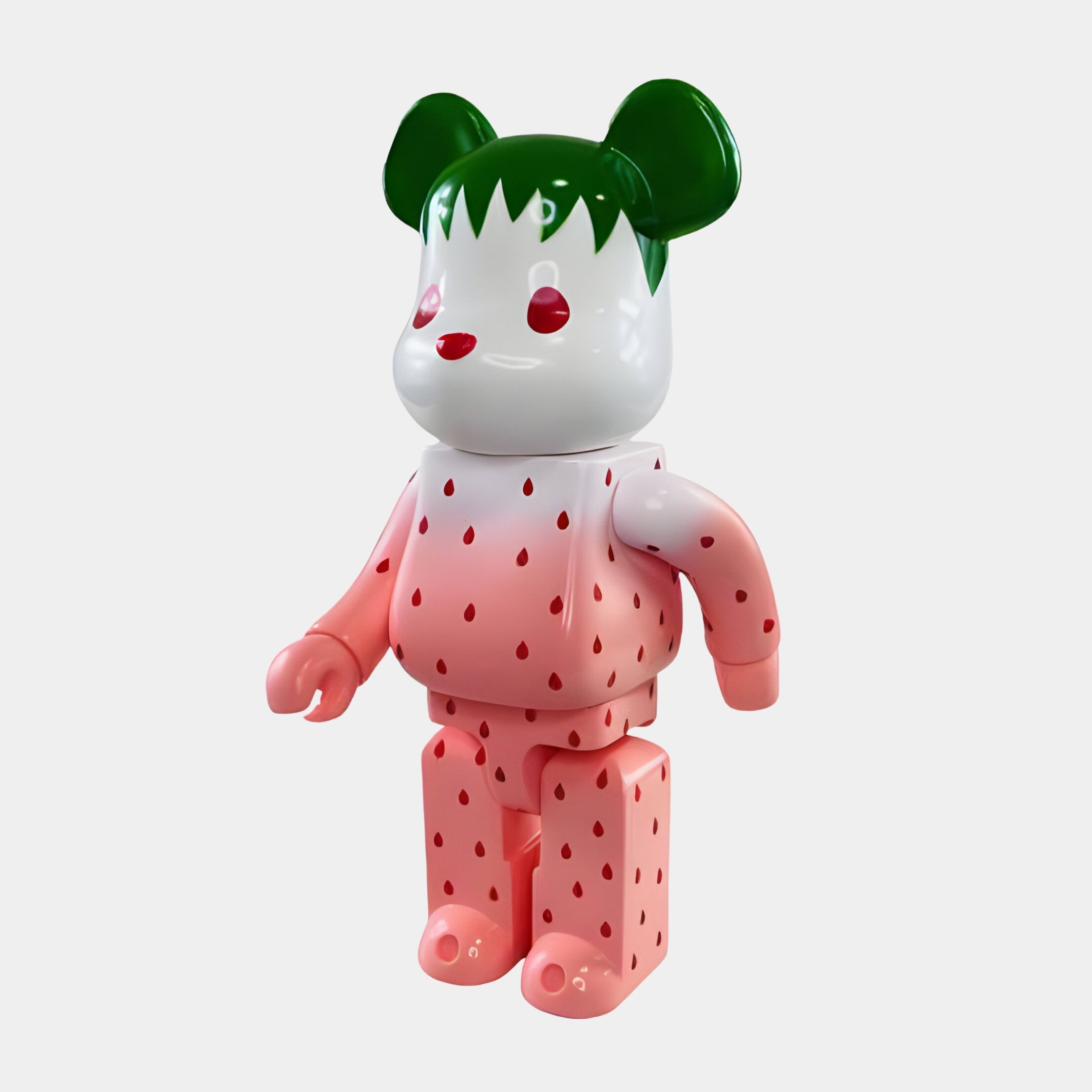 The Seeded Gradient Bear Sculpture - 70cm by Giant Sculptures features modern craftsmanship with a white head, green ears and hair, red eyes, and pink limbs accented by strawberry seed-like spots for a charming fruity appeal.