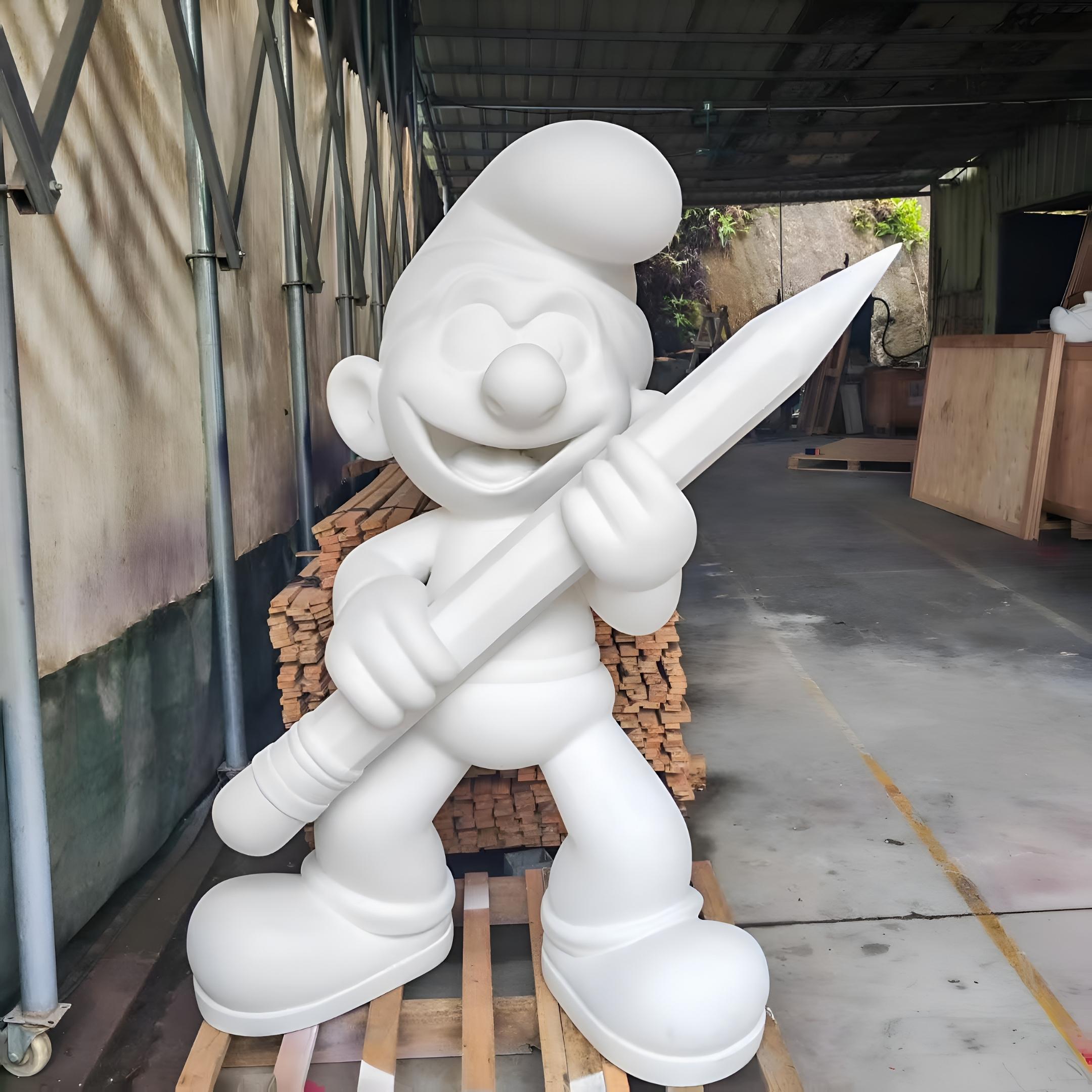 Unpainted white fibreglass Giant Pencil Smurf Standing Sculpture 150cm in primer finish, holding an oversized pencil, displayed in a workshop on wooden pallets.