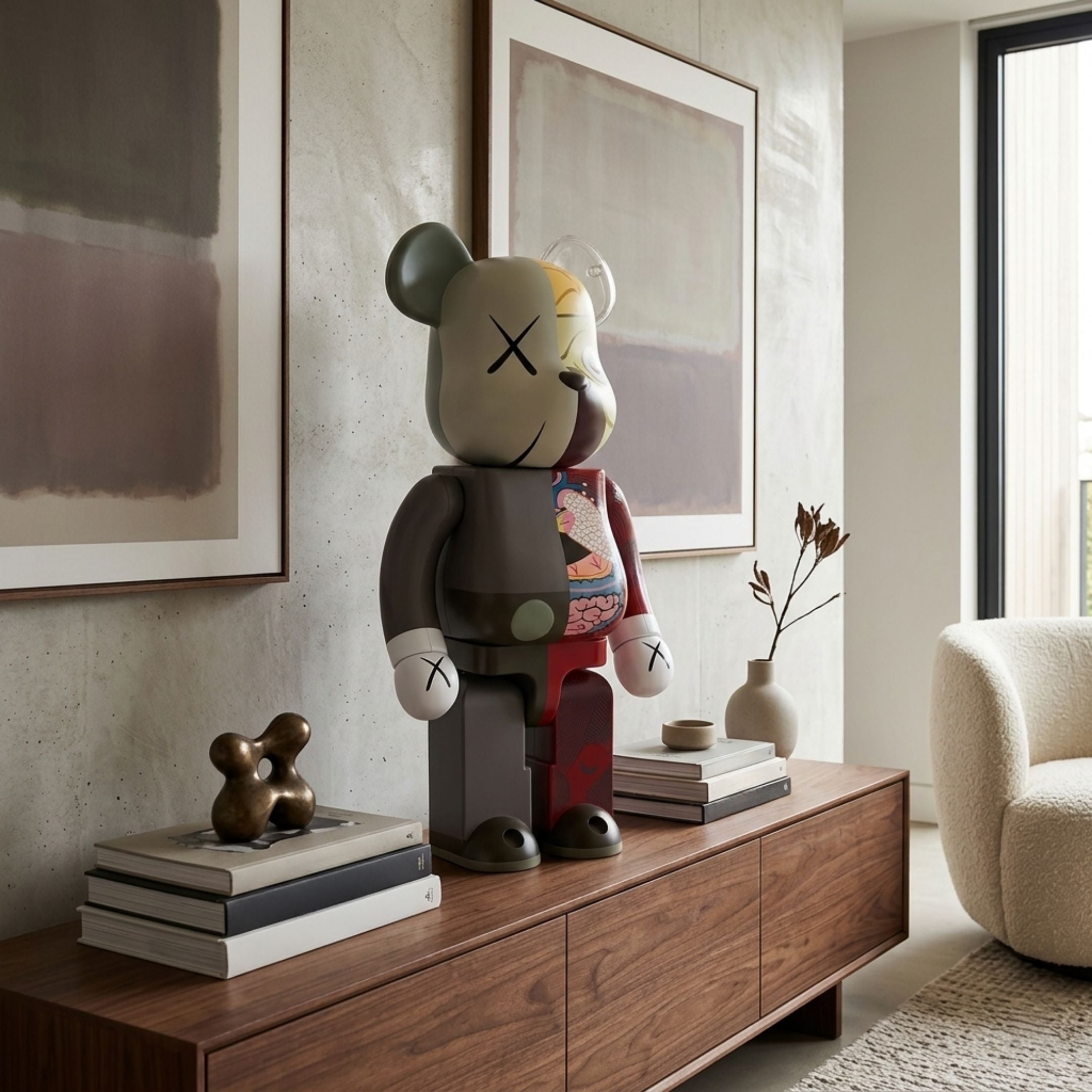 Split Anatomy Rouge Bear Sculpture, 70cm, split-body design with anatomical detail, displayed on a wooden sideboard in a living room with framed art and armchair.