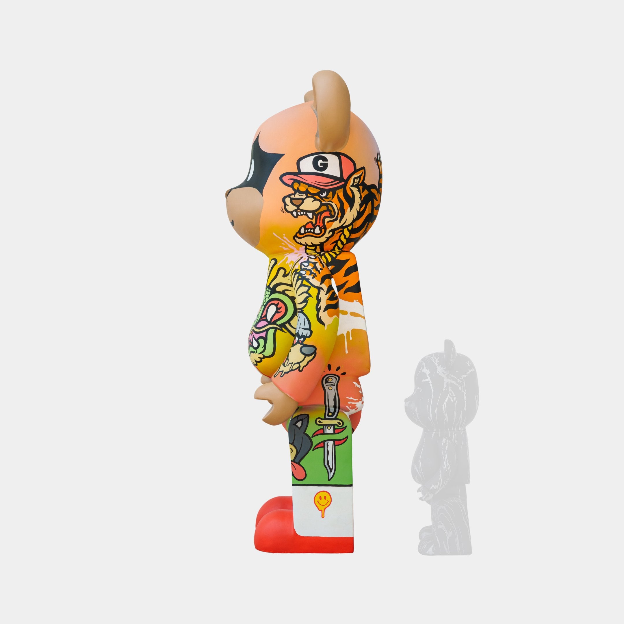 Side view of the 135cm Lucky Paws Bear Sculpture by Giant Sculptures, showcasing vibrant street art elements with a cartoon face, tiger stripes, sword graphic, and red shoes. A shadow image behind it symbolizes prosperity and protection.