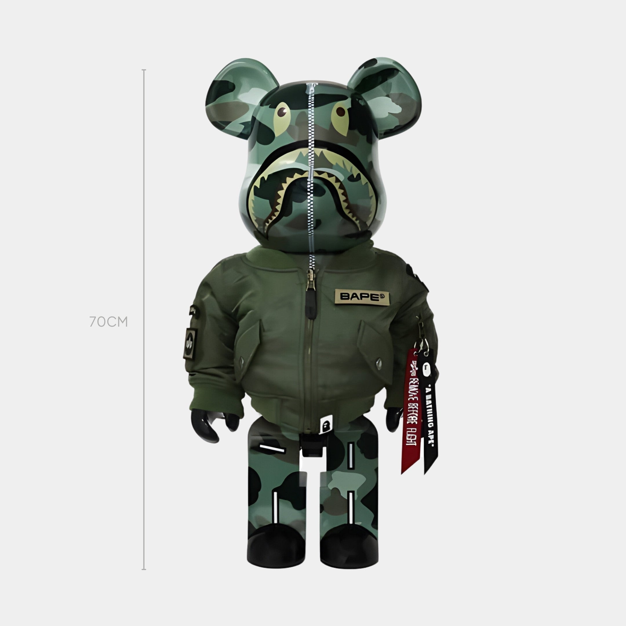 The Giant Sculptures Tactical Flight Bear Sculpture - 70cm is crafted from impact-resistant resin, features green camouflage, a shark face head, and a green bomber jacket with BAPE and patches. Displayed against a plain white background.