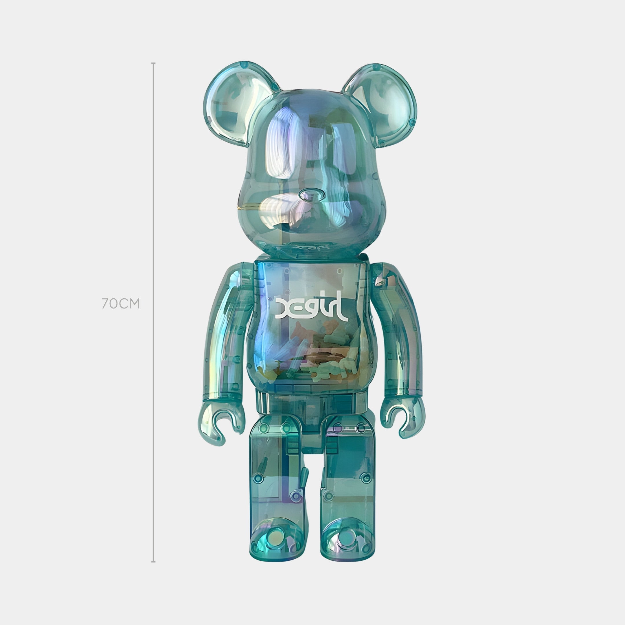 The Aqua Mirage Bear Sculpture - 70cm by Giant Sculptures is a translucent blue-green bear with X-girl on its chest, standing upright against a plain white background.
