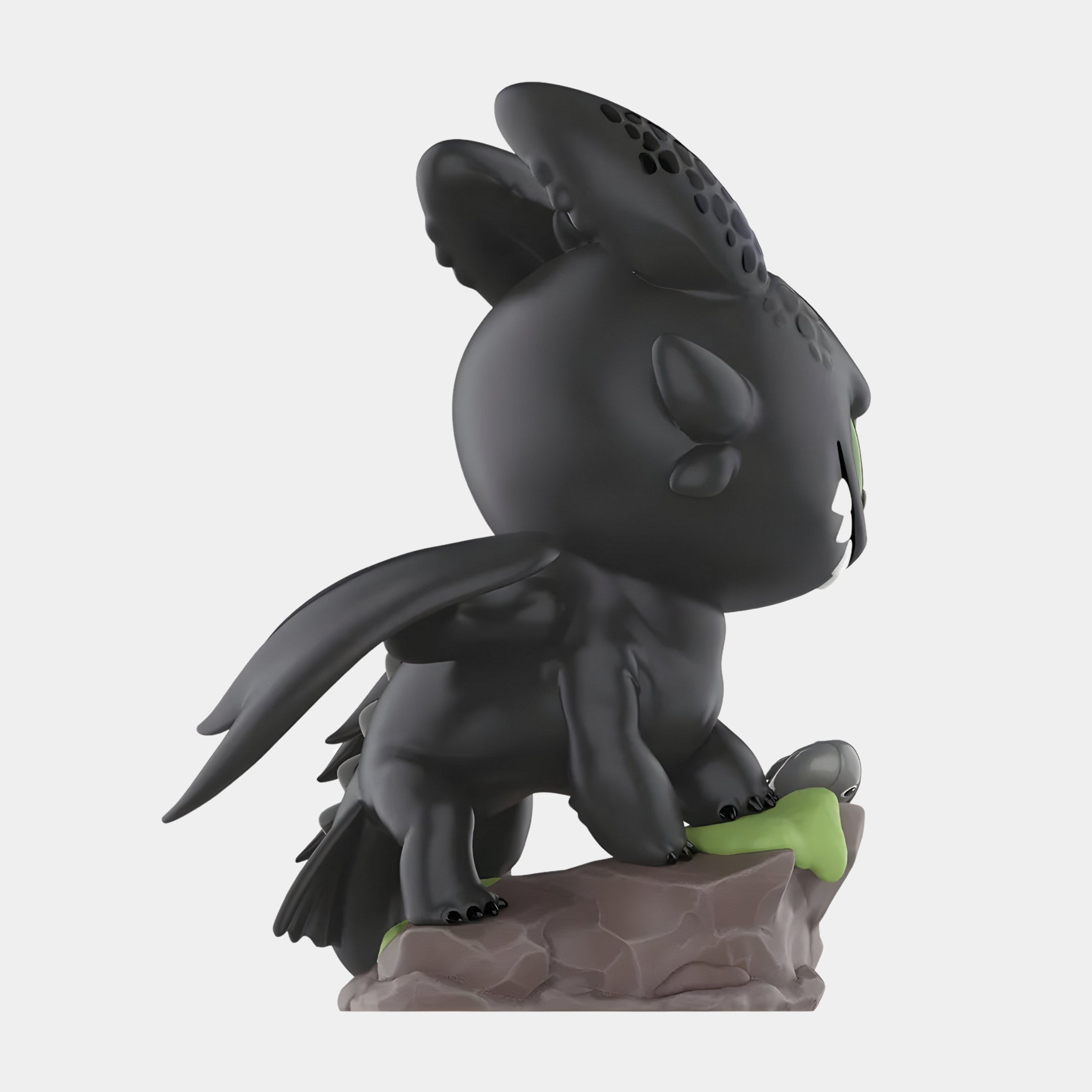 The Dragon Bond Toothless Labubu Sculpture - 100cm by Giant Sculptures features Toothless standing on a mossy rock with black wings, large ears, and a textured head—ideal for fans and collectors alike.
