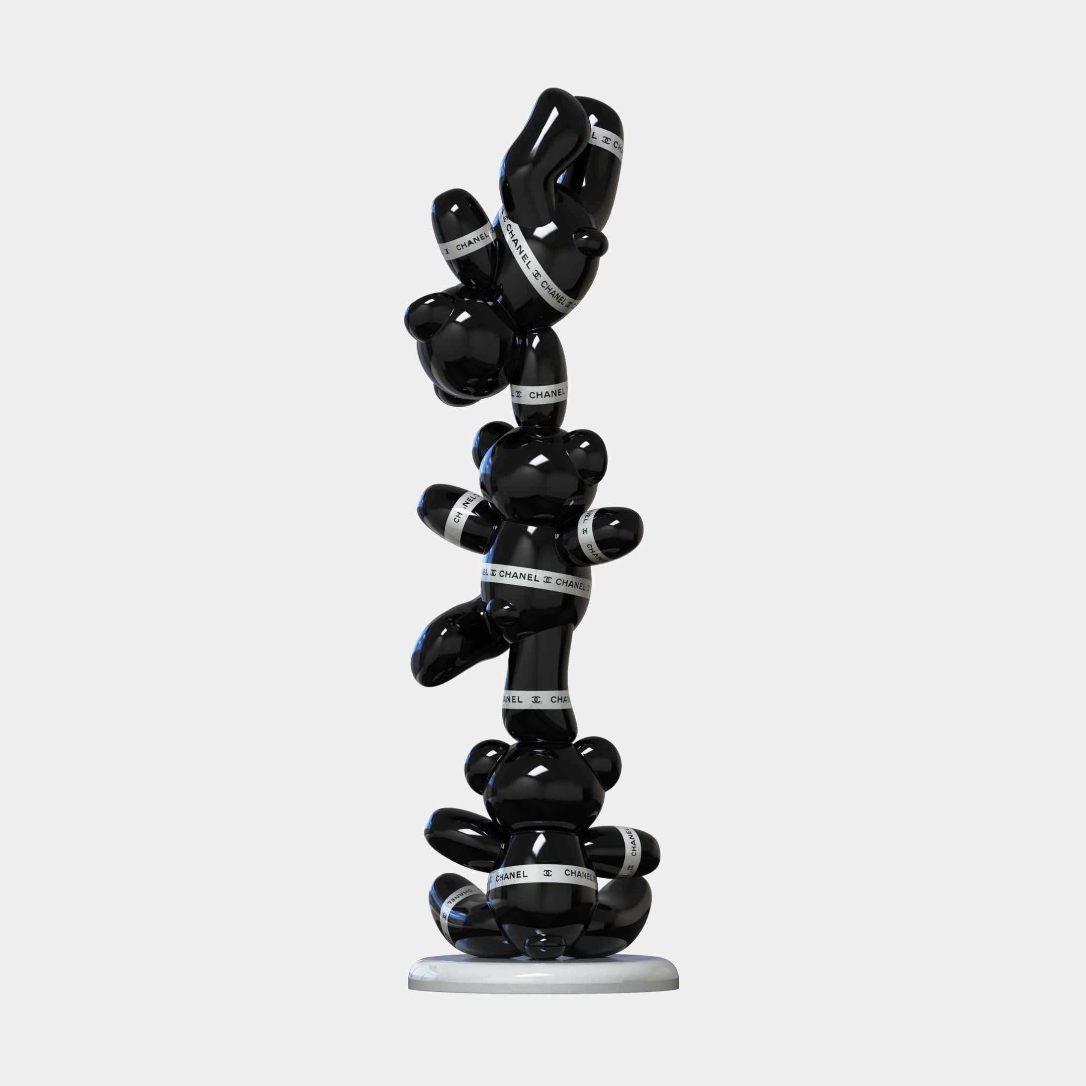 The Gacko Black Chanel Triple Bear Sculpture by Giant Sculptures stands 90cm tall, featuring shiny black bears with white CHANEL bands on a circular base—an eye-catching piece of contemporary art decor.