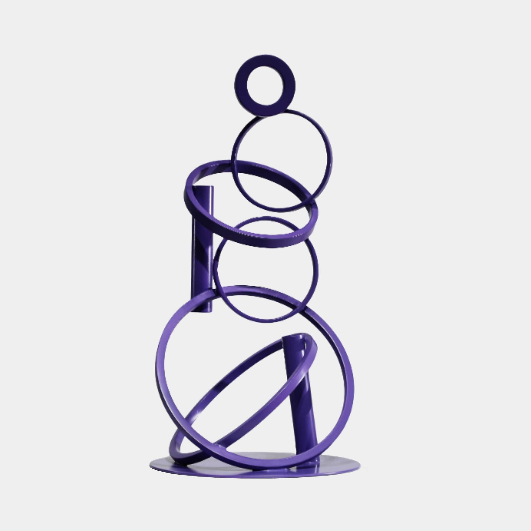 Giant Sculptures Purple Stacked Circles Metal Sculpture 65cm, deep violet rings of graduating sizes tilted along a central spine on an oval base.