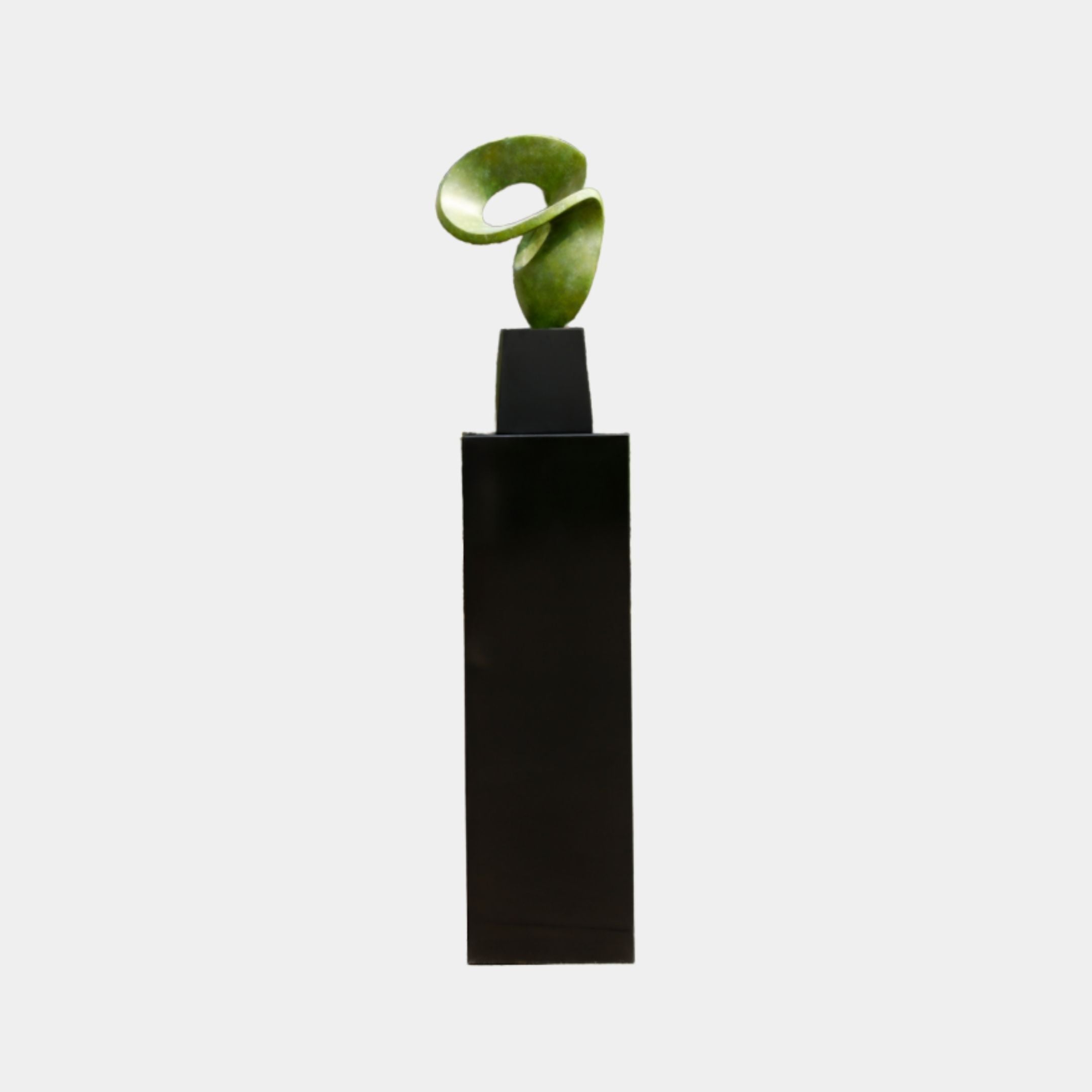 Moss Green Organic Knot Abstract Pedestal Sculpture by Giant Sculptures, a twisting jade-like loop displayed on a tall black plinth against a white background.
