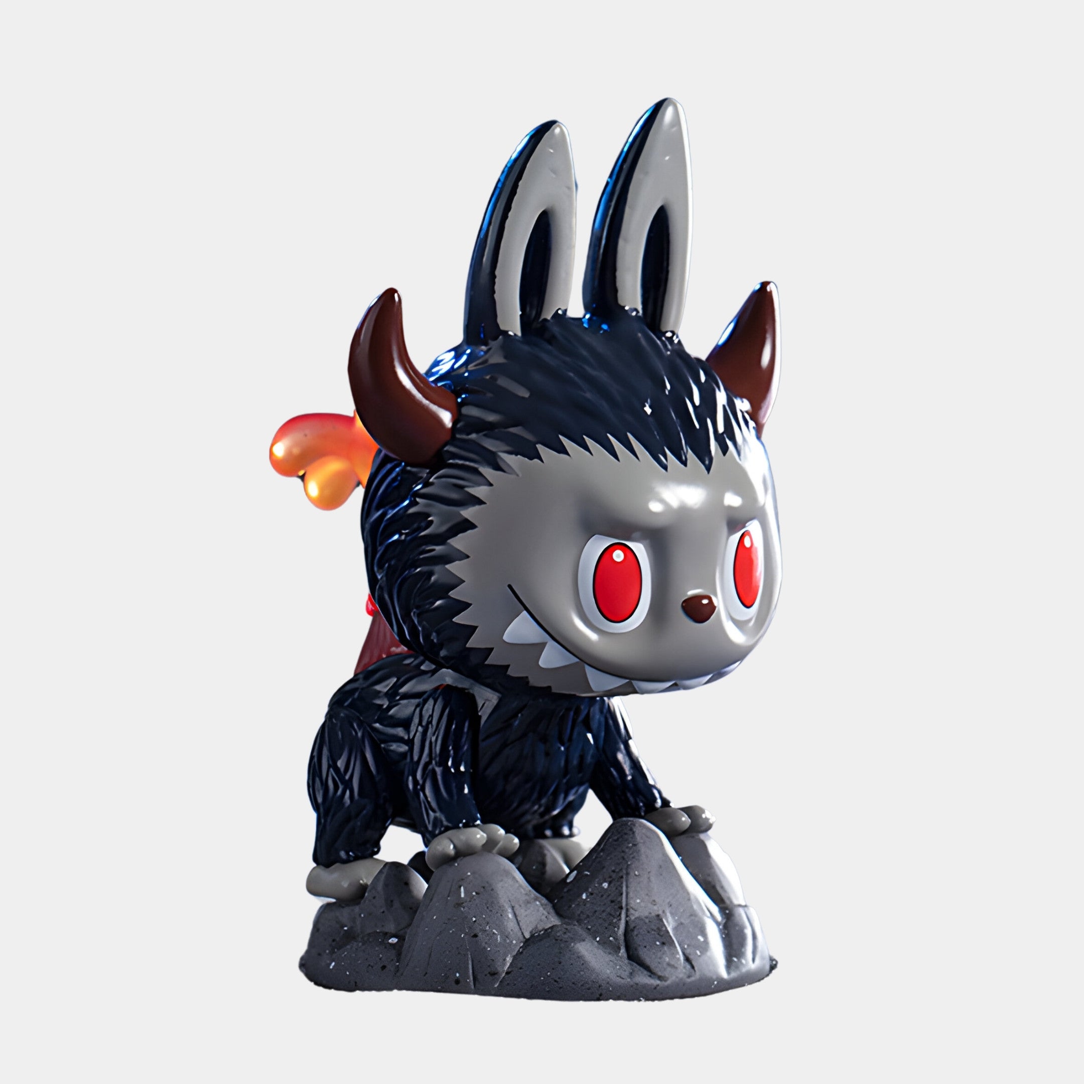 The Monsterverse Volcano Kaiju Labubu Sculpture by Giant Sculptures (100cm) features black fur, red eyes, two horns, rabbit-like ears, a red cape, small flame tail, and stands on gray rocks with an expressive mischievous look.