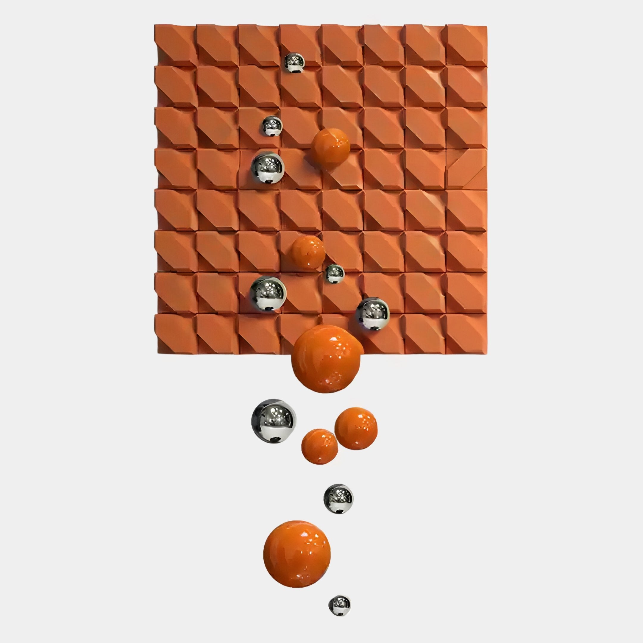 The Orbina Orange 3D Wood Relief Wall Art With Metal Ball by Giant Sculptures features a square orange grid with repeating geometric patterns and shiny orange and silver spheres arranged diagonally, accented with metal, on a white background.