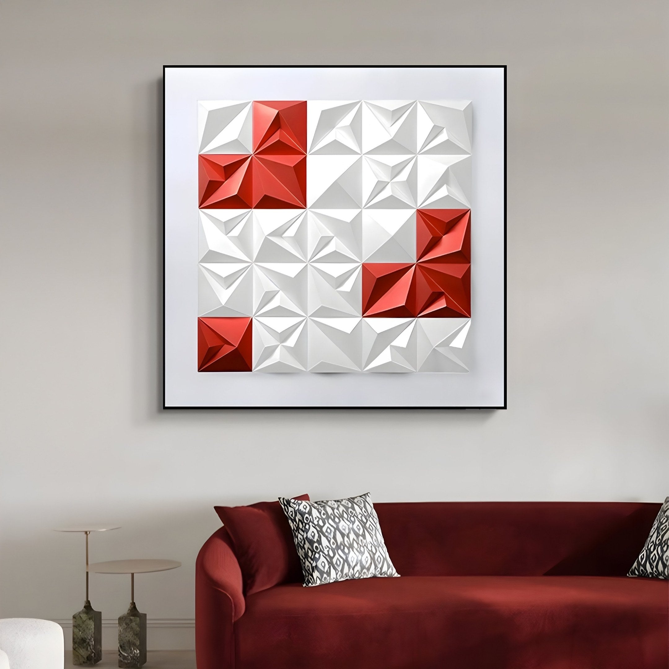 A living room features Giant Sculptures Geometrica White & Red Accent 3D Wood Relief Wall Art with modern geometric triangles. Below, a red sofa is decorated with patterned pillows, and two decorative bottles sit on a round side table.