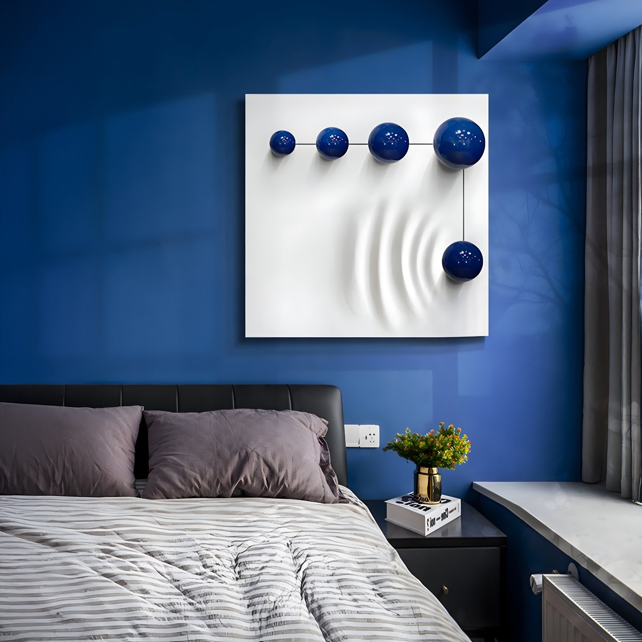 A modern blue-themed bedroom showcases a Galactica White Wood Relief 3D Wall Art With Linear Blue Metal Ball by Giant Sculptures above a bed with gray bedding. A small plant on the windows ledge complements the rooms sleek design.