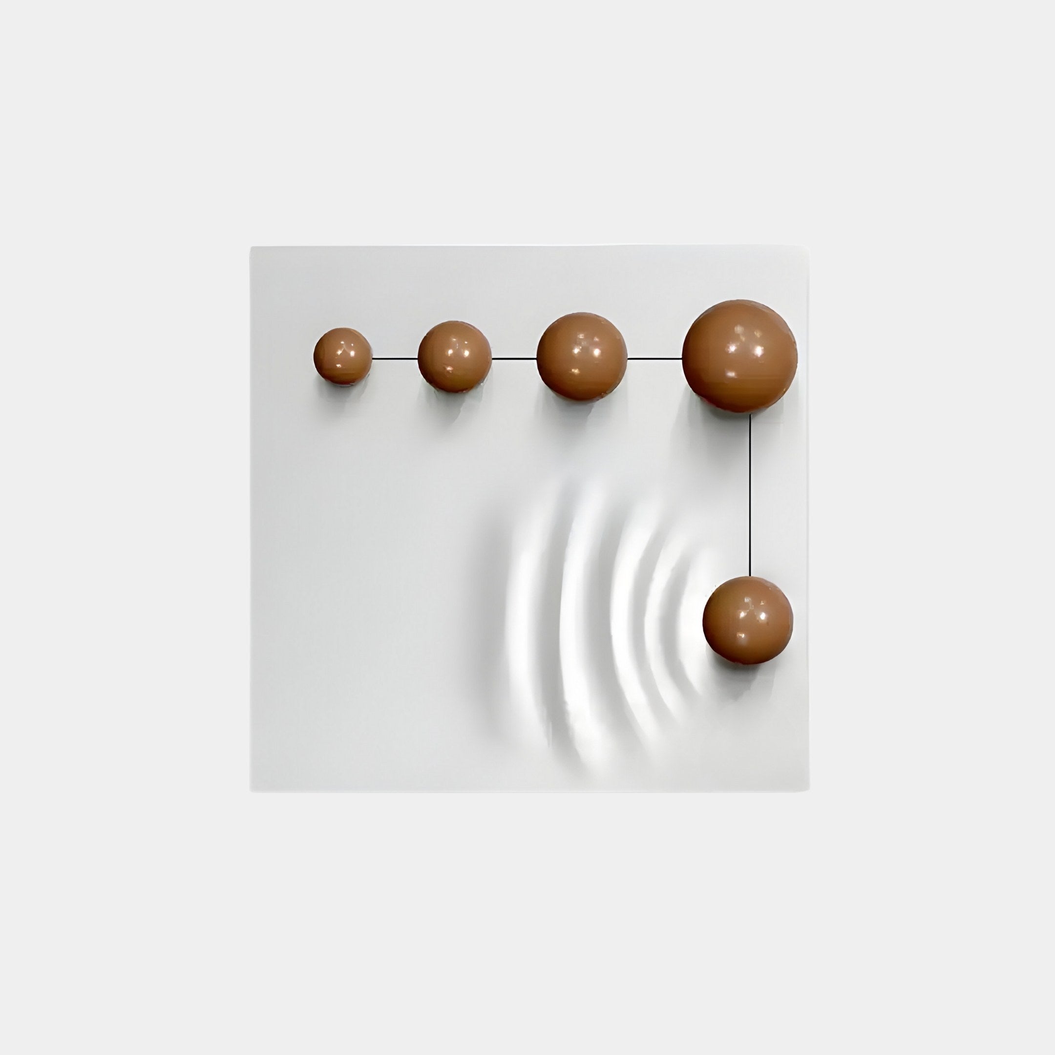 The Galactica White Wood Relief 3D Wall Art by Giant Sculptures features a minimalist design with a white square panel and five brown spheres crafted from linear brown metal in a stepped pattern. The largest spheres ripple-like shadow enhances the simplicity against the plain gray background.