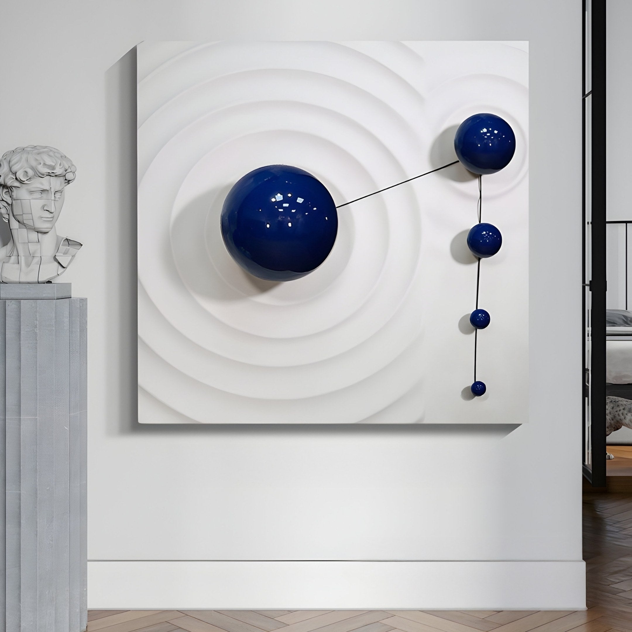 The Galactica White Wood Relief 3D Wall Art With Blue Metal Ball by Giant Sculptures is an elegant piece featuring a white relief of concentric circles, large and small blue metal balls linked by thin rods, and a classical bust on the left, all set against a luxurious wooden floor.