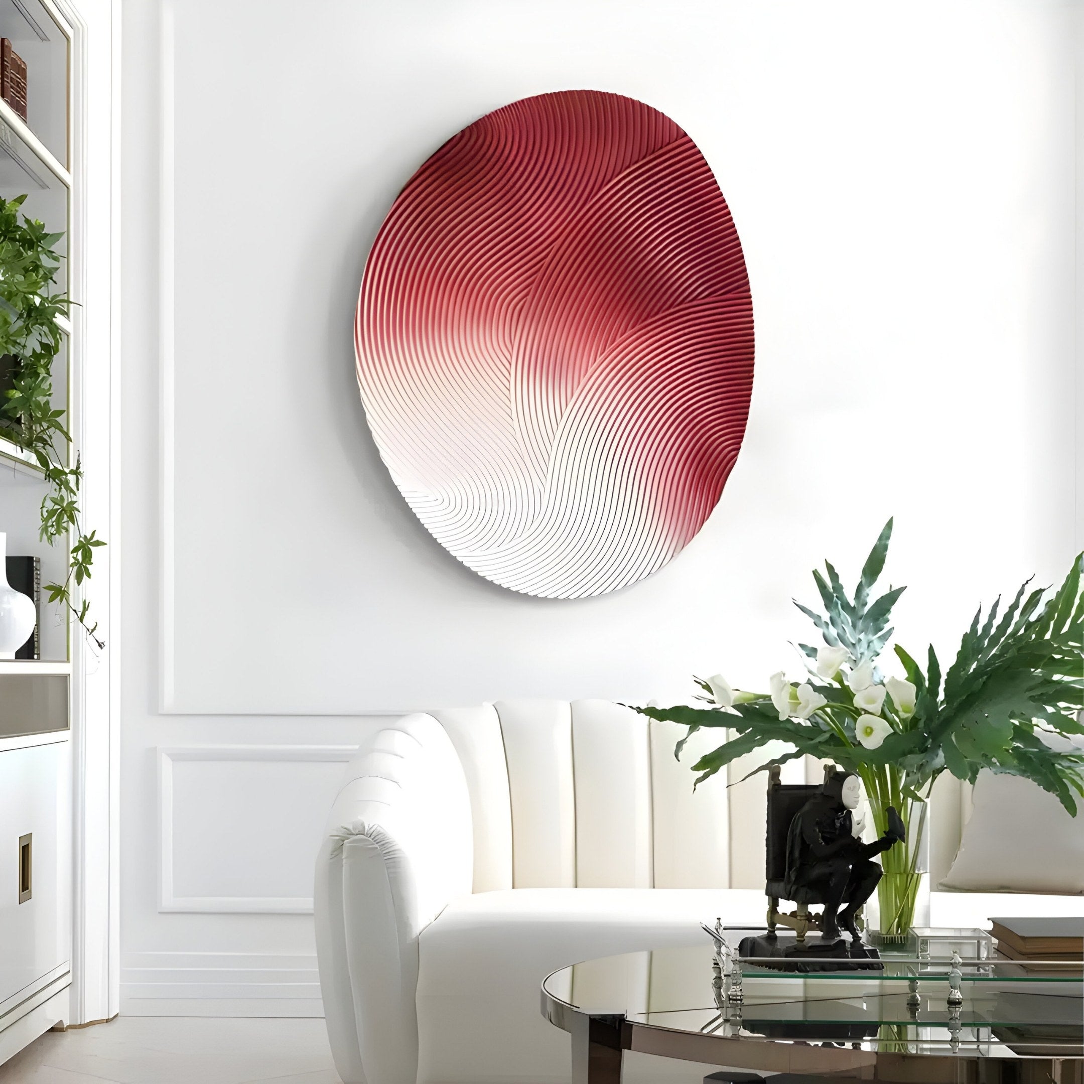 A modern living room features Giant Sculptures Fluctus Red Textured Sandstone Wood Relief 3D Wall Art on a white wall. Below it, a white curved sofa offers comfort, while a glass coffee table with a figurine and vase of white flowers complements the lush greenery from surrounding plants.