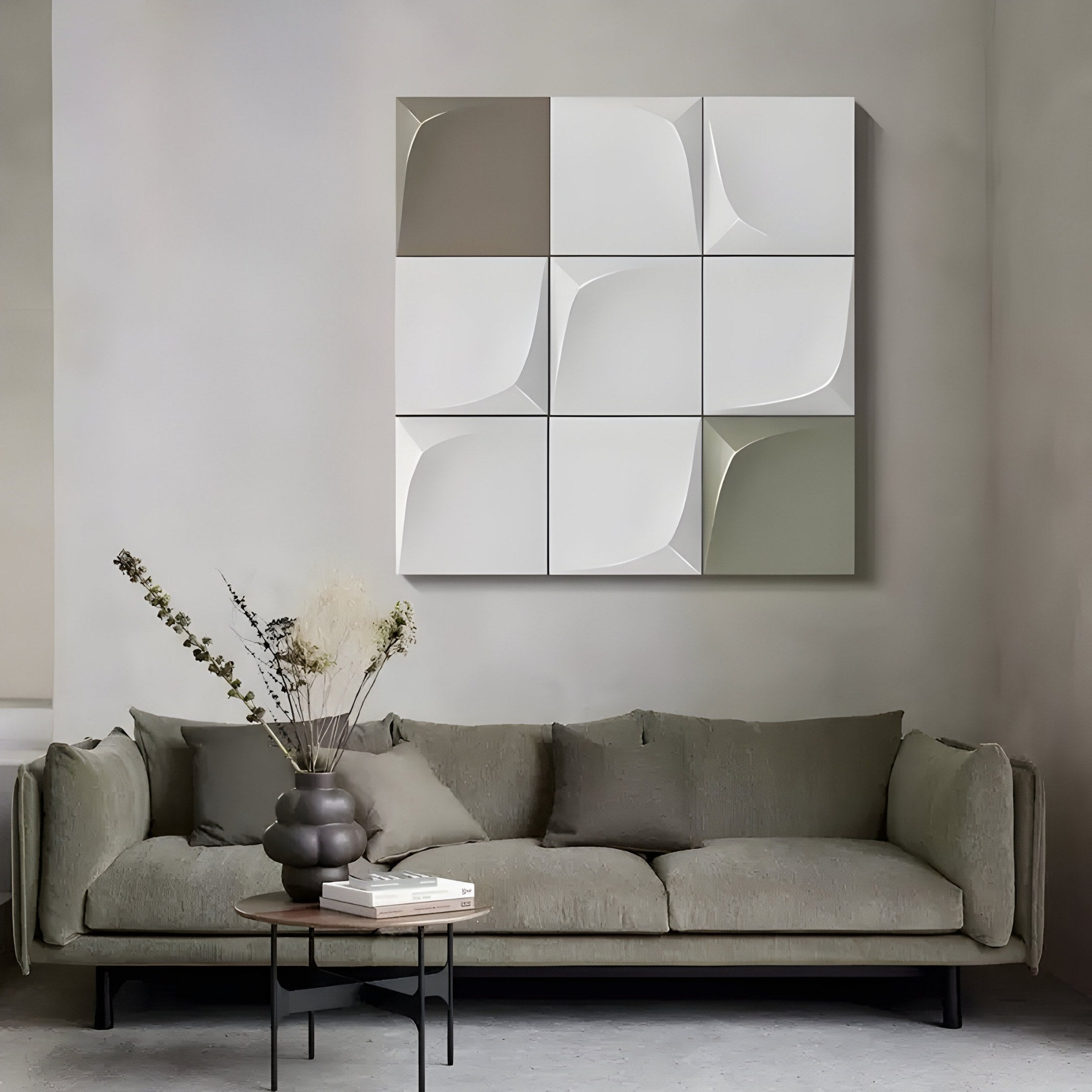 A minimalist living room features a gray sofa with a small round table holding dried flowers, while the Olive & Grey Grid 3D Wood Relief Wall Art by Giant Sculptures hangs above, adding geometric elegance to the space.
