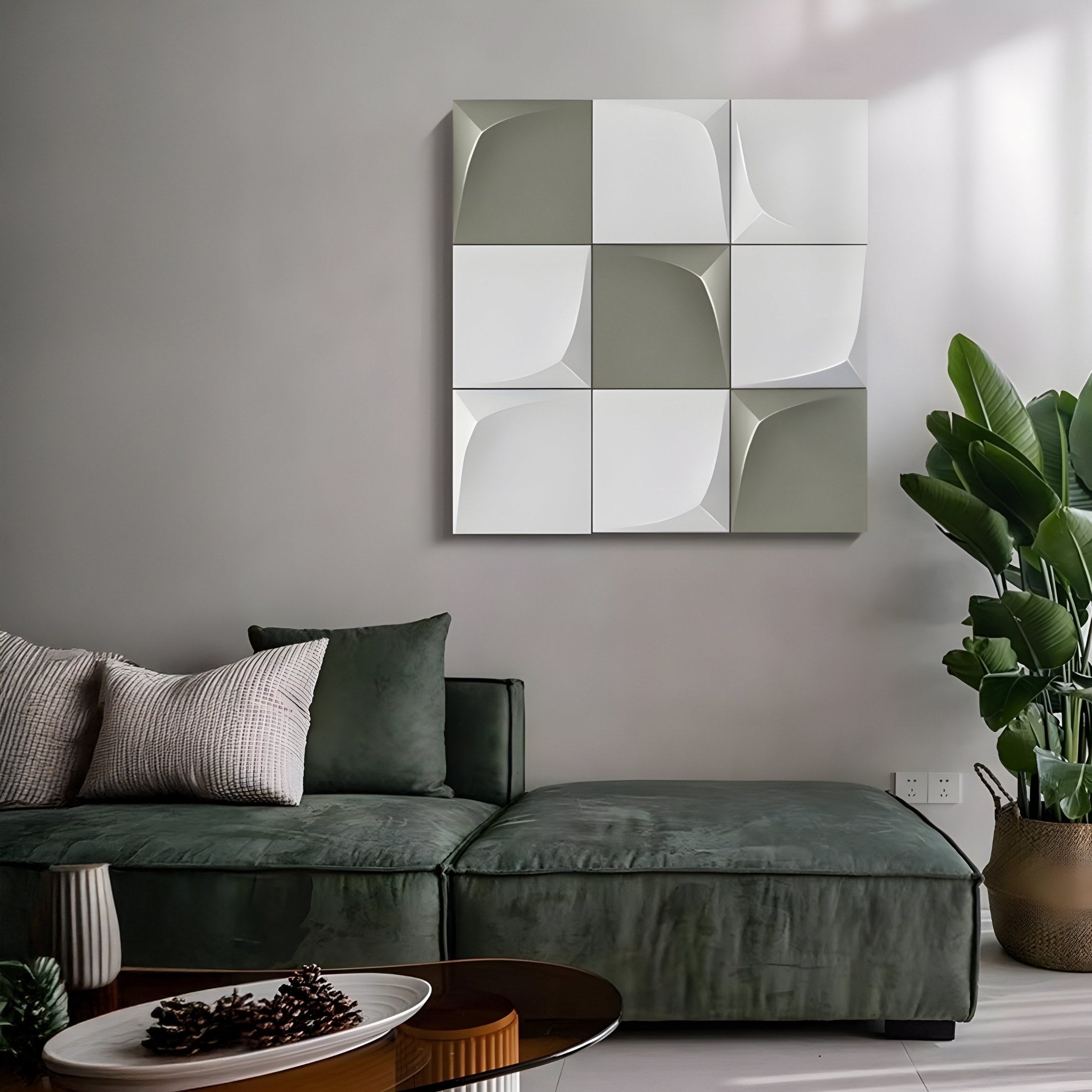 A modern living room showcases a green velvet sectional sofa with white pillows, highlighted by the Curvatura White & Olive Grid 3D Wood Relief Wall Art from Giant Sculptures. A large green plant stands in the corner, while a round coffee table elegantly anchors the space.