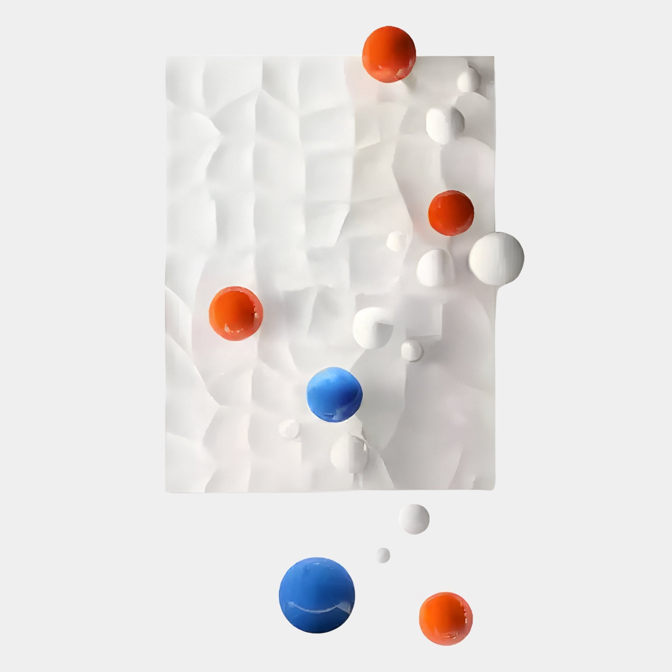 The Orbison White Vertical 3D Wood Relief Wall Art by Giant Sculptures features a textured white rectangular panel with blue, orange, and white floating metal balls arranged randomly on and around the rectangle against a light gray background.