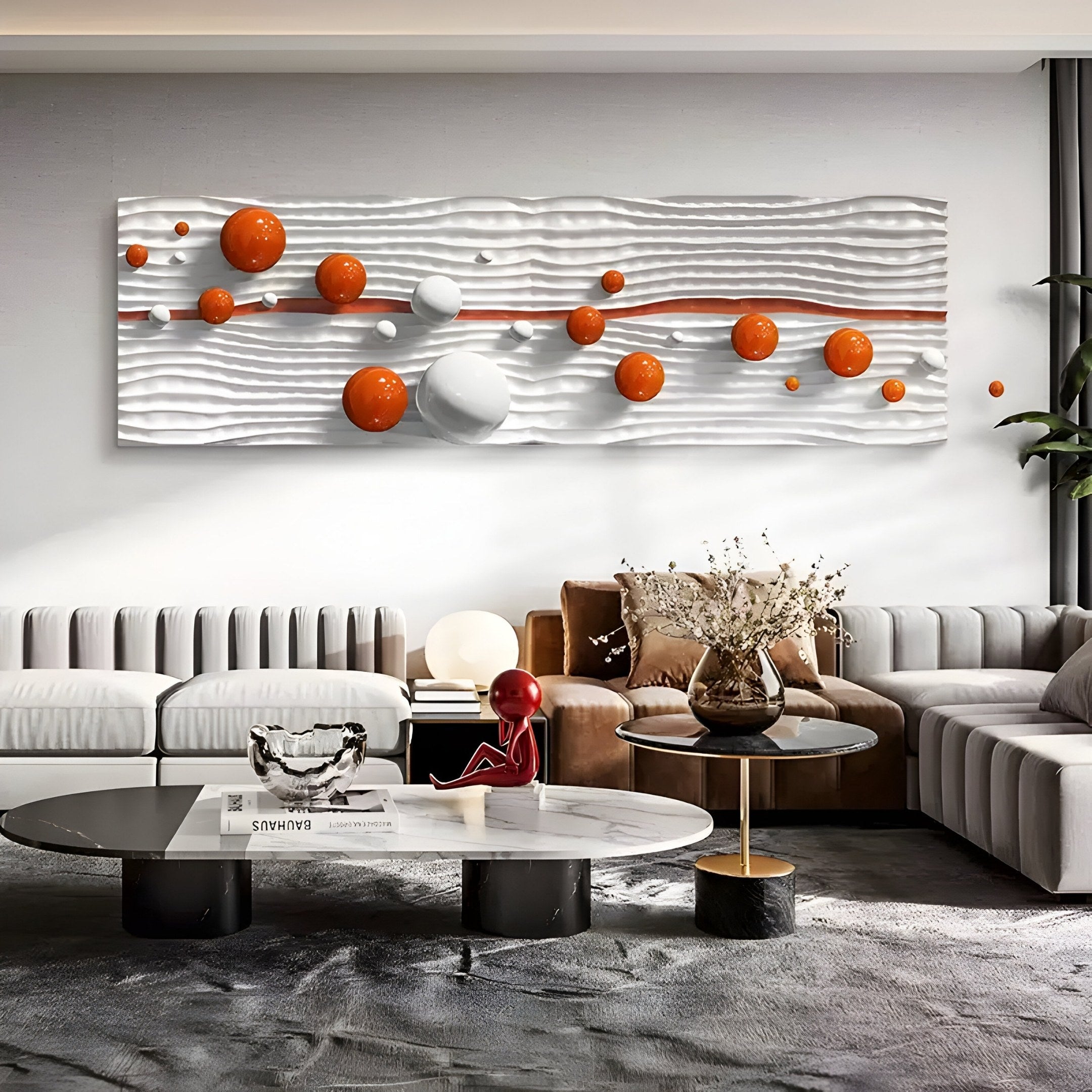 A modern living room features Giant Sculptures Lustra Orange & White 3D Wood Relief Wall Art with Metal Ball. Gray and beige sofas surround round coffee tables adorned with decor, a plant, and a bouquet in a vase, showcasing minimalist and contemporary design.