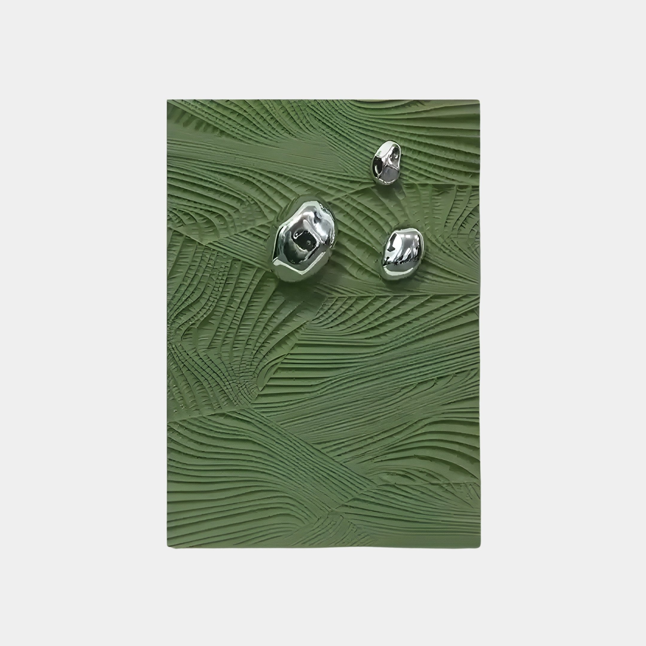 The Verdara Green Wood Relief 3D Wall Art from Giant Sculptures features a textured green rectangle with three shiny, irregular silver shapes. The wavy, leaf-like pattern adds depth, and the plain white background provides a striking contrast.