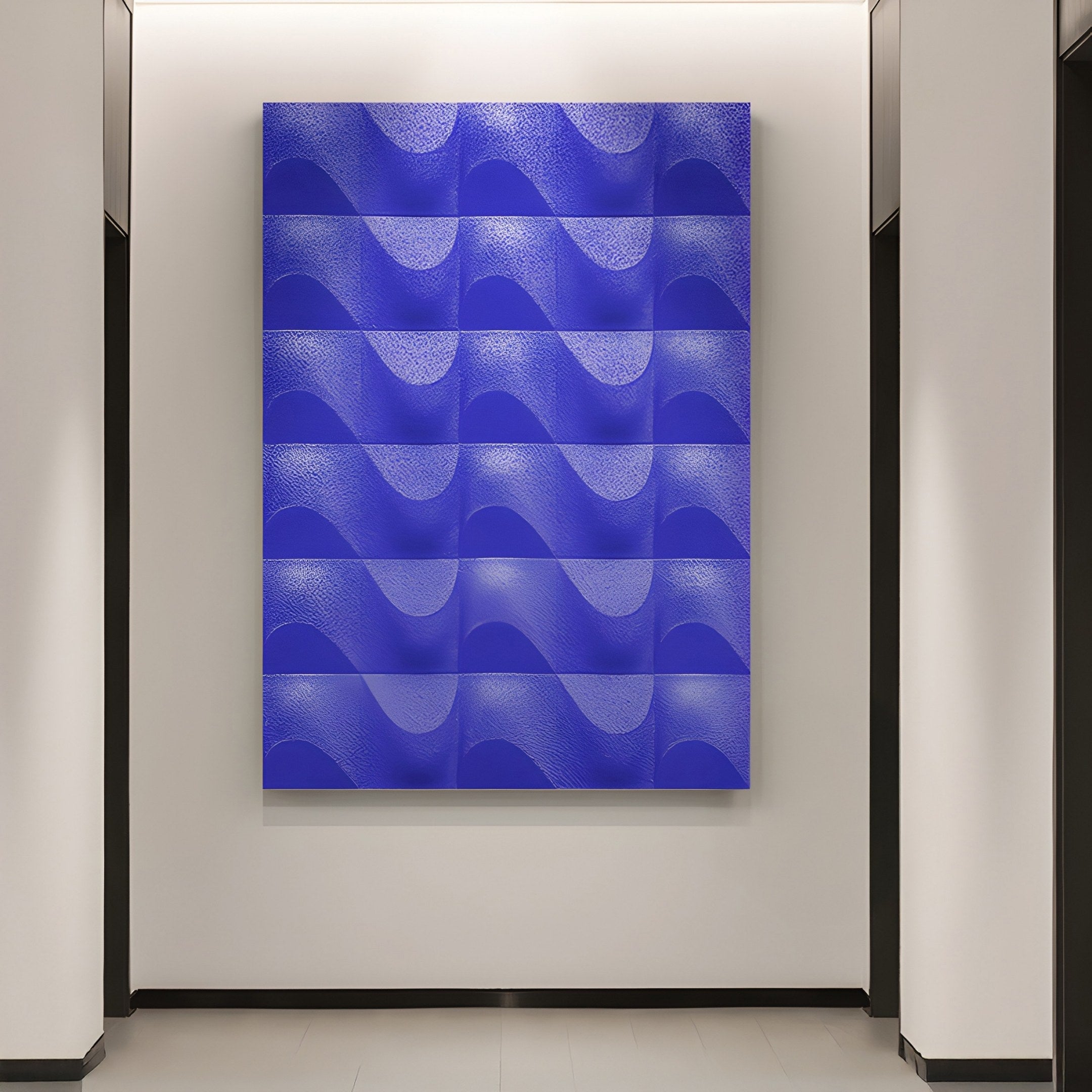 The Ondula Textured Iris Blue Wood Relief 3D Wall Art by Giant Sculptures hangs between two dark doorways on a white wall. This large abstract piece consists of several panels with wave-like patterns, creating a cohesive effect.