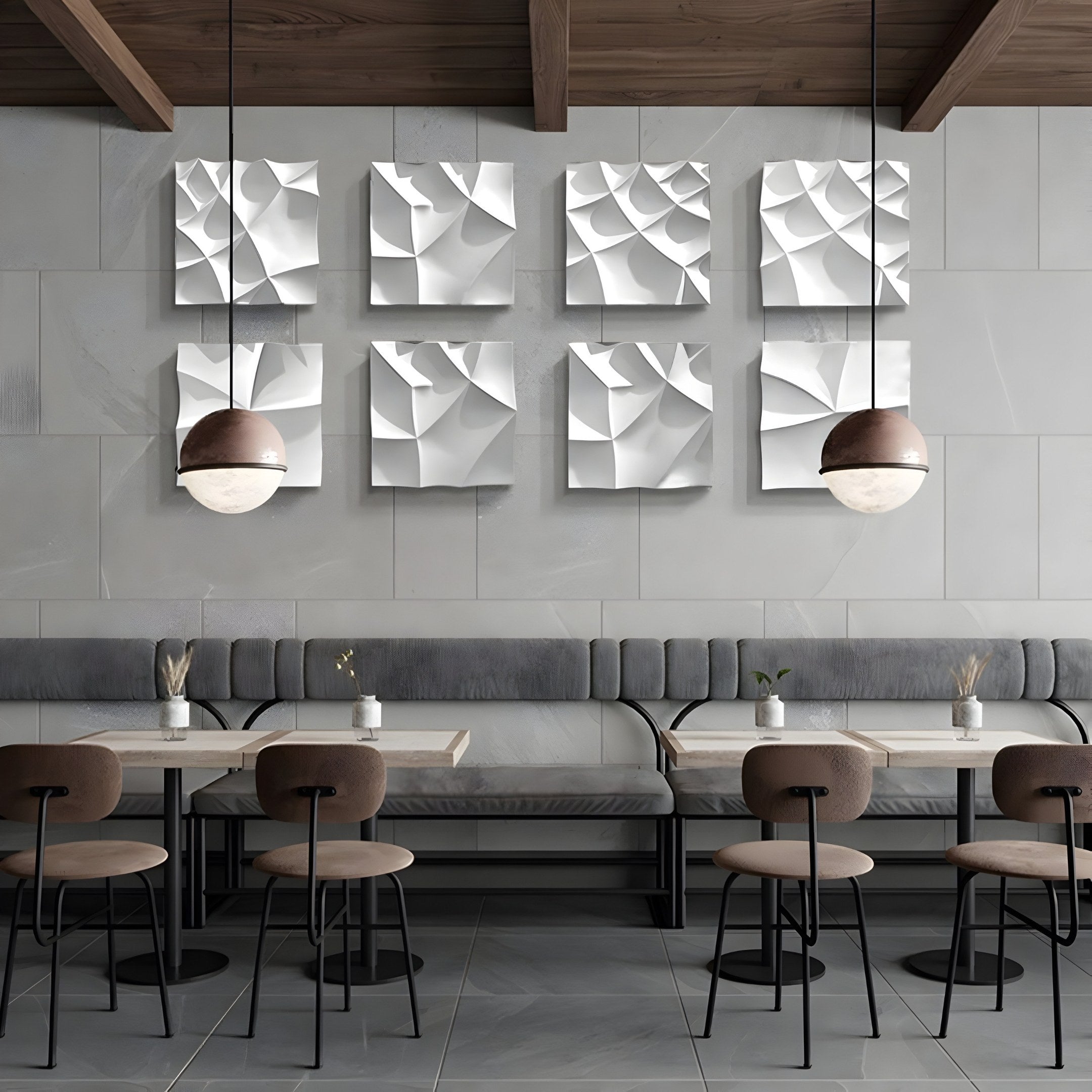 The modern café interior features a row of tables and chairs, with Tessara II White 3D Wood Relief Wall Art by Giant Sculptures adorning the walls. Pendant lights hang from the wooden ceiling, enhancing the minimalistic and contemporary decor.