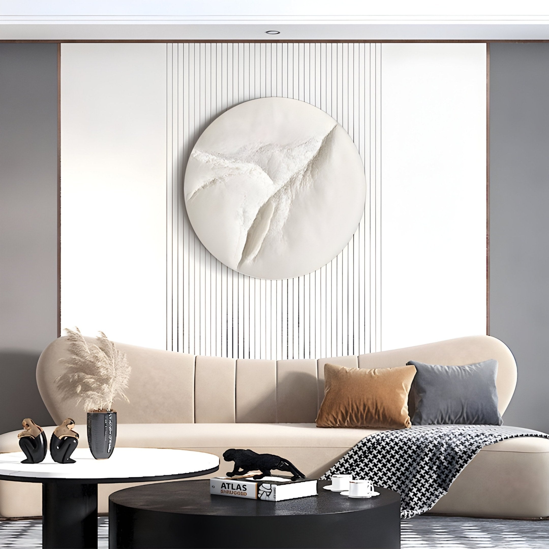 A modern living room has a curved beige sofa against a gray and white panel wall. Above, the Selene IV White Sandstone Textured 3D Wood Relief Wall Art by Giant Sculptures adds elegance with its textured design. A round coffee table with decor, including a black sculpture, complements cushions and a checkered throw.