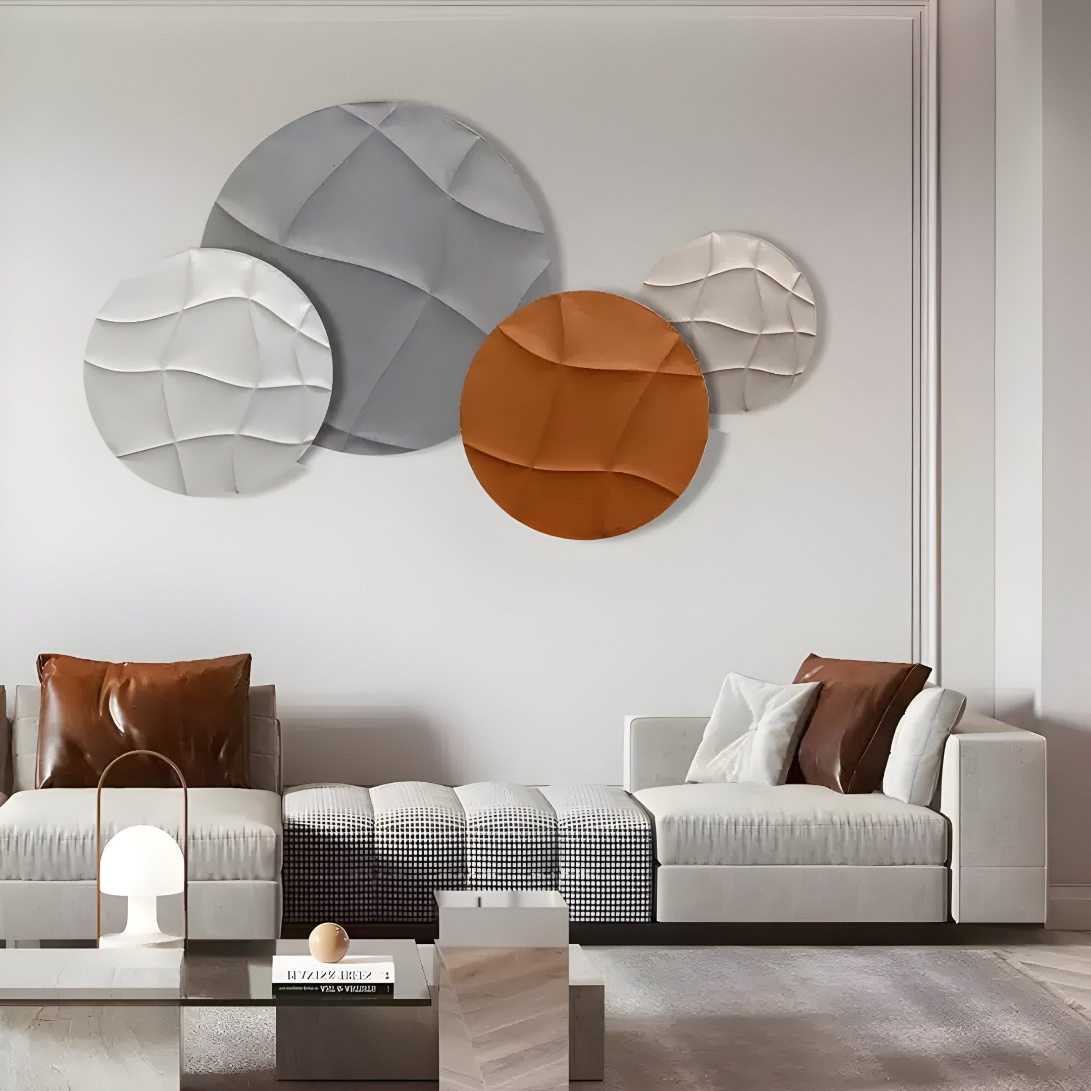 A modern living room features a white couch with brown and gray cushions, a wooden coffee table, and a small lamp. The wall displays Giant Sculptures Orbita 4-Set circular sand and rust 3D wood relief artworks, enhancing the ambiance.