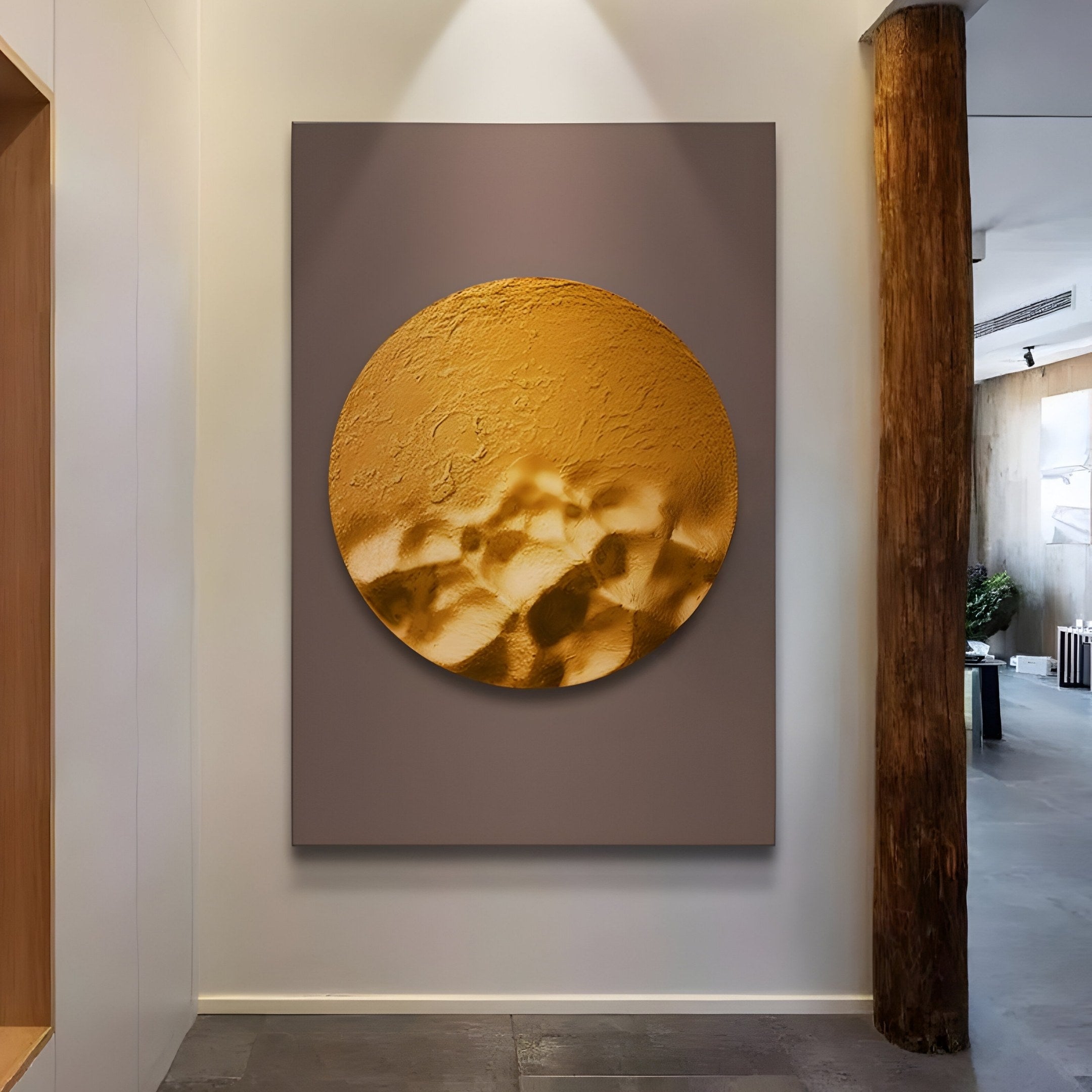 The Solivis Amber 3D Wood Relief Wall Art by Giant Sculptures showcases a large hand-painted golden circle with abstract patterns on a gray background, enhancing minimalist interiors with neutral walls and a wooden column, adding depth to the space.