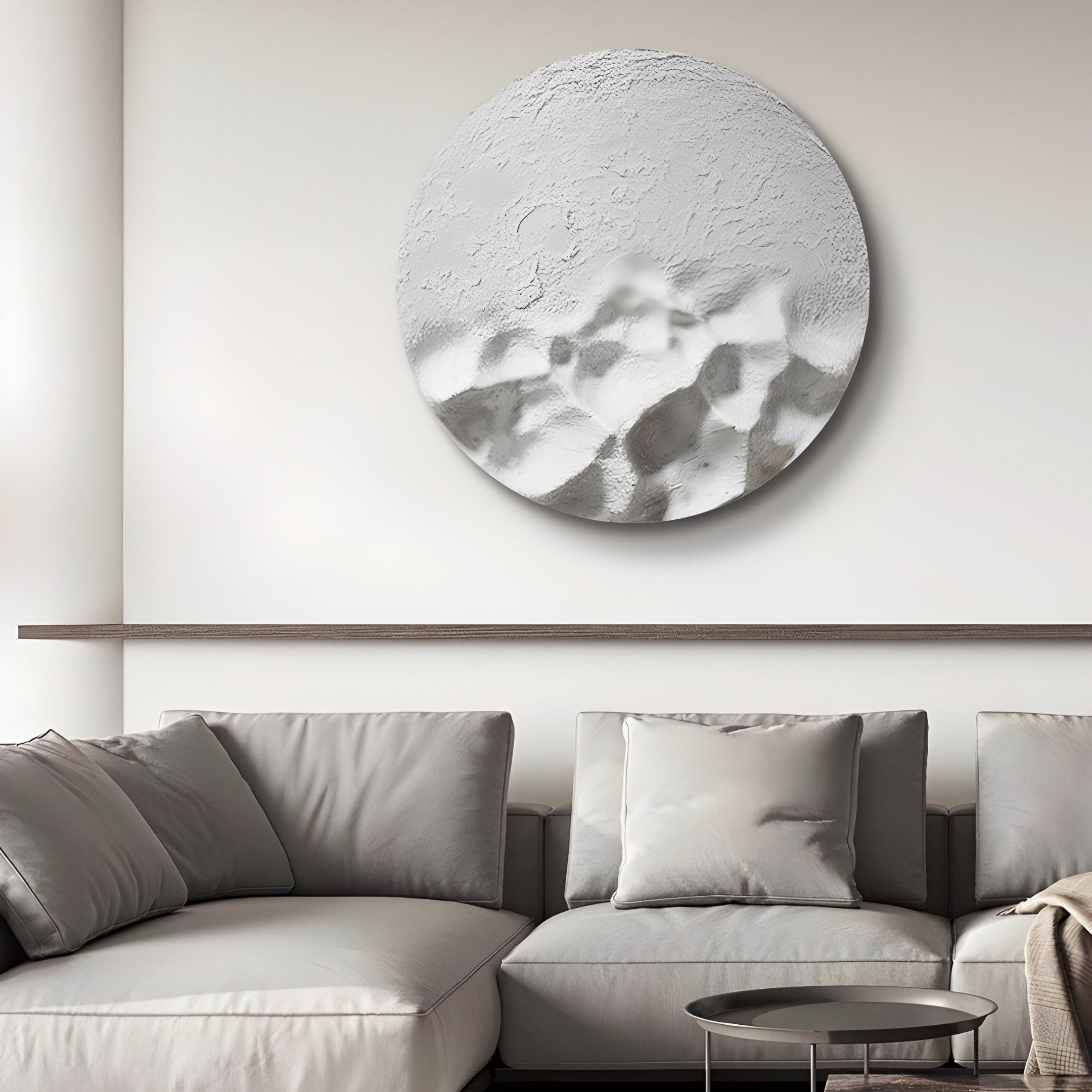 A modern living room showcases a light gray sofa with matching cushions. Above it, the Solivis Frost White Round 3D Wood Relief Wall Art by Giant Sculptures adds texture in white and gray as a focal point. A small, dark round coffee table completes the minimalist decor.