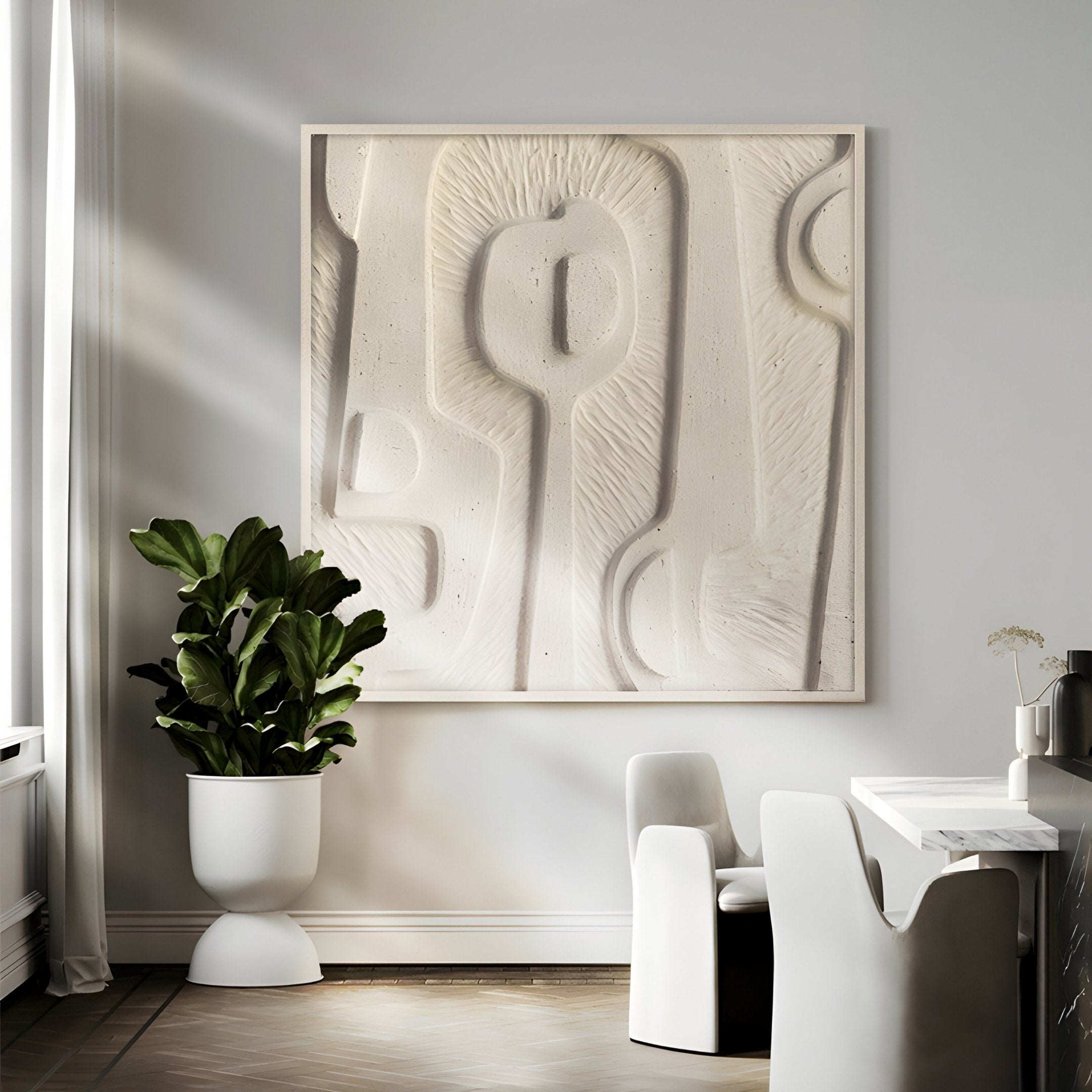 In a modern dining room, the Terravura Square Sandstone I 3D Wood Relief Wall Art by Giant Sculptures takes center stage with its textured design. Below, a white round table is encircled by sleek armless chairs. A leafy plant in a sandstone finish pot brings greenery to the minimalist setup.