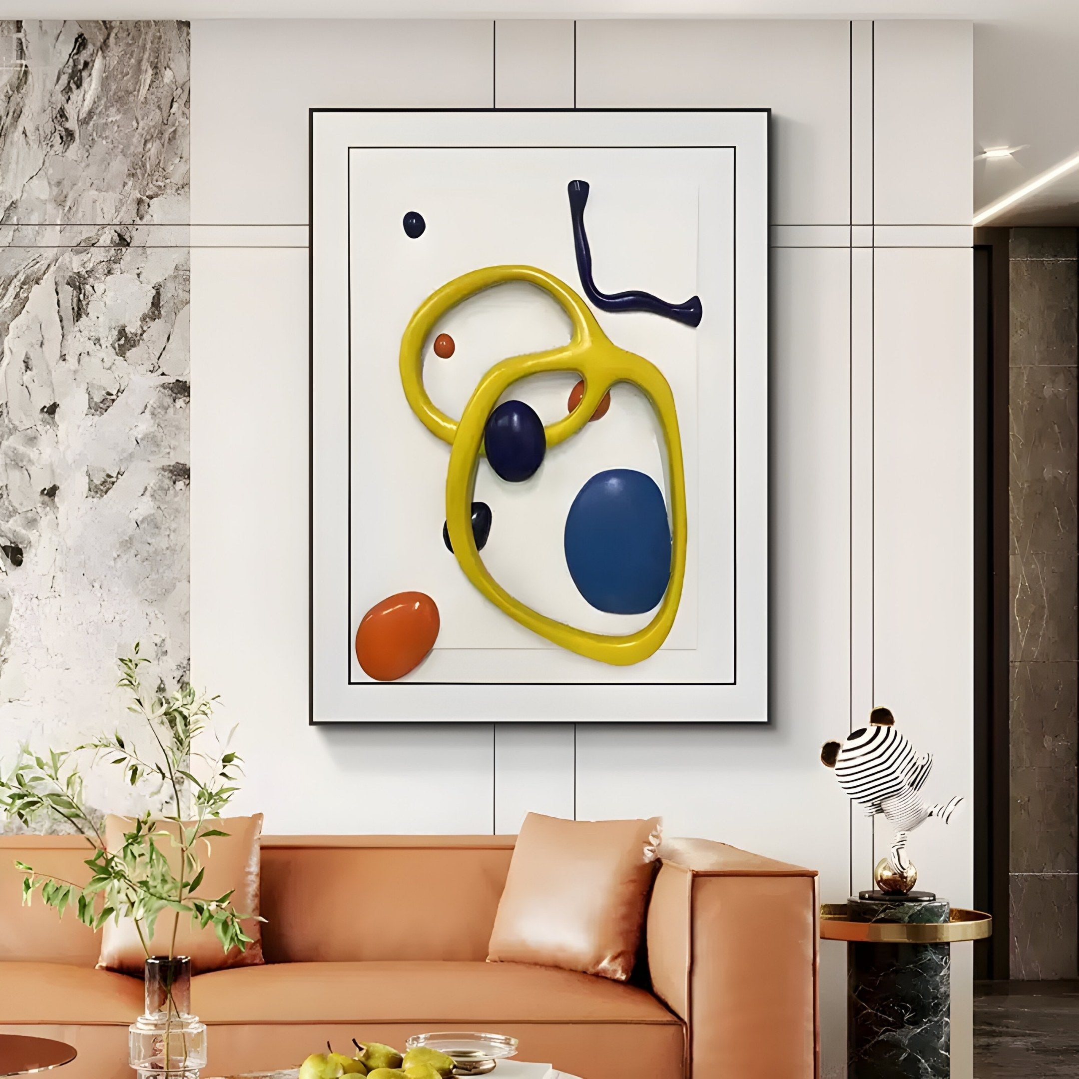 A modern living room features a tan sofa with beige pillows and leather accents. Above, the Vitrus Yellow & Blue Abstract Wood Embossed 3D Wall Art by Giant Sculptures captivates. A small table nearby holds a striped vase and a bowl of fresh green apples.