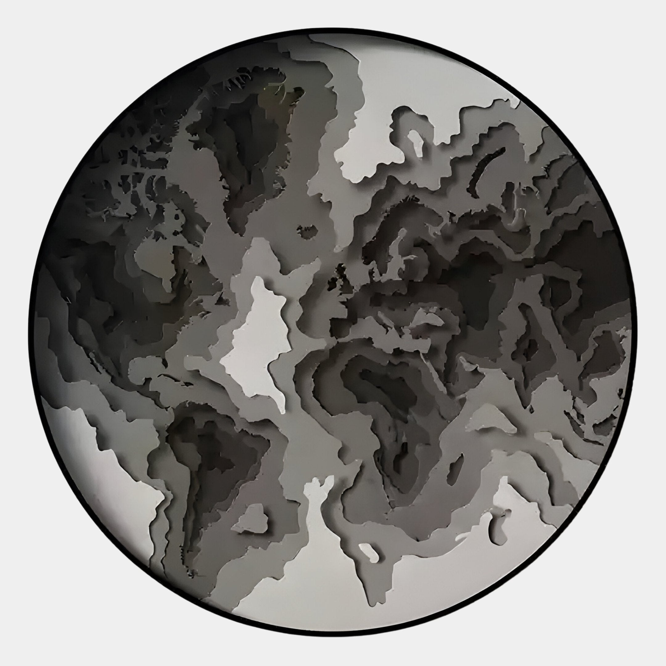 The Terranova Ash Grey Round Wood Carving 3D Wall Art by Giant Sculptures showcases layered, wavy 3D shapes in gray, black, and white tones within a black-bordered circle for a sophisticated topographic look.