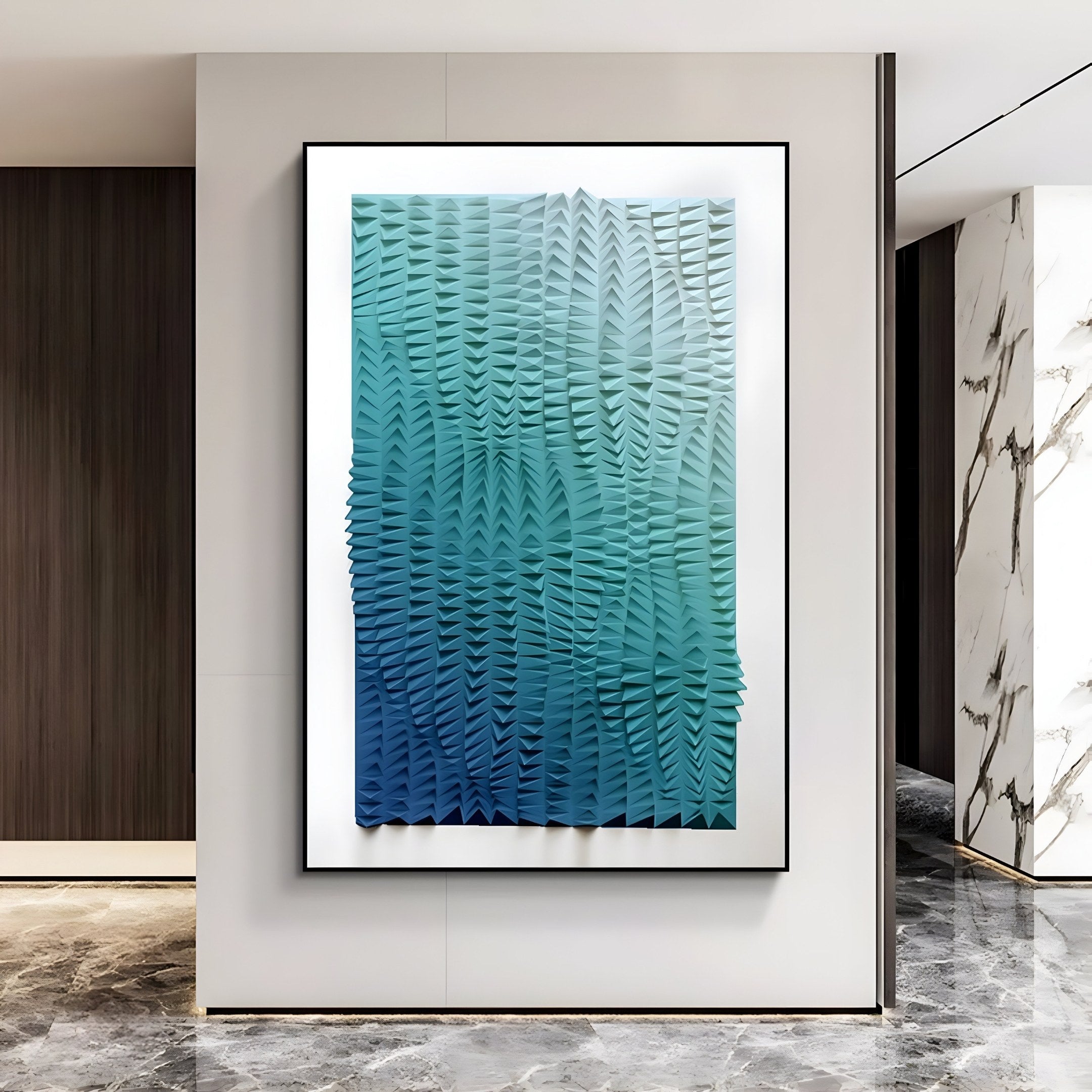 A modern interior features the Elytrum Blue Gradient Hand-Painted 3D Wood Relief Art by Giant Sculptures. Its textured abstract design in blue and green captivates on a white wall, harmonized with marble and wood paneling, and beautifully contrasted against the reflective gray marble floor.