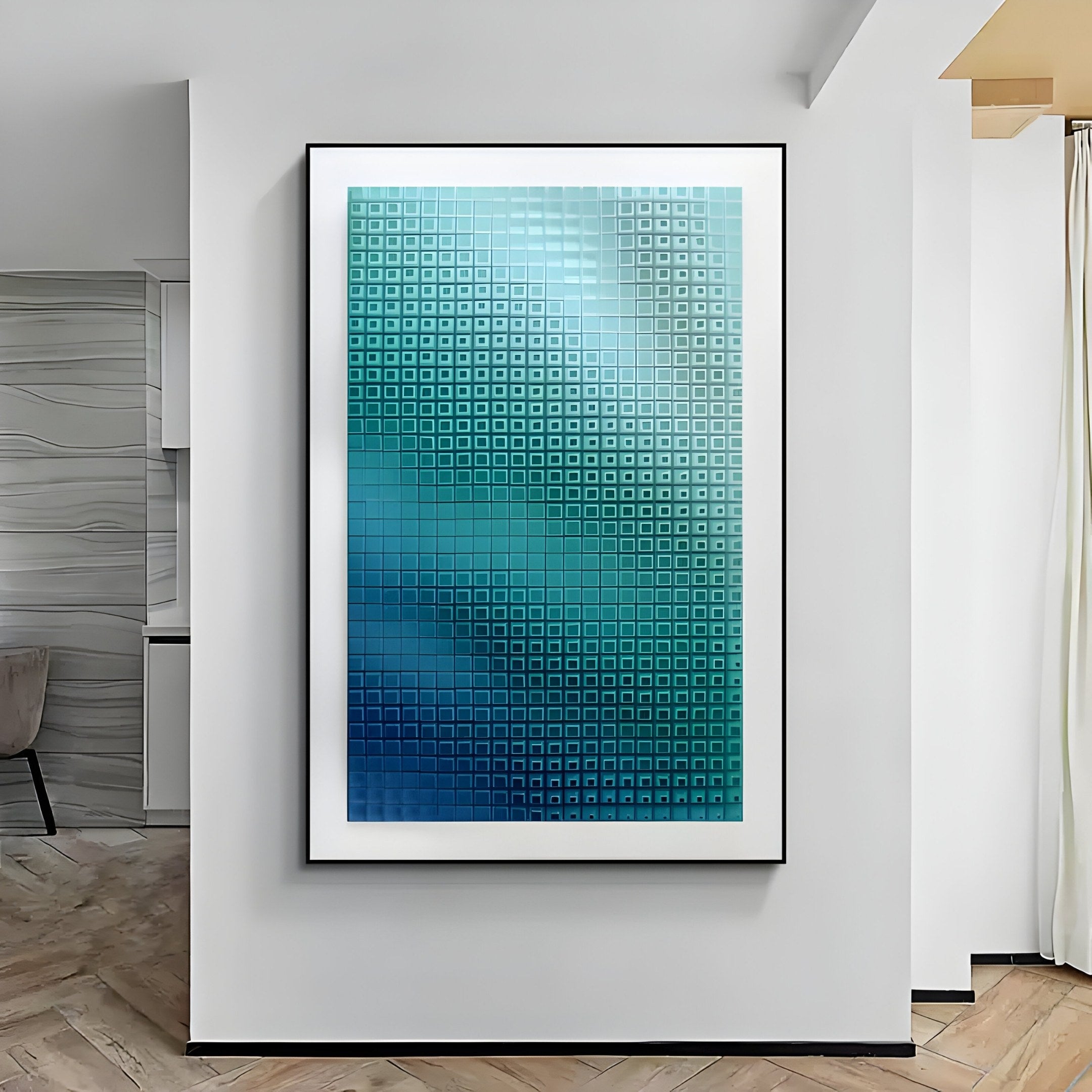 A modern interior displays the Elytrum Blue Grid Gradient Hand-Painted Wood Relief 3D Wall Art by Giant Sculptures, showcasing a geometric design of blue and teal squares with a pixelated effect. Light-colored walls and wooden floors highlight its depth.