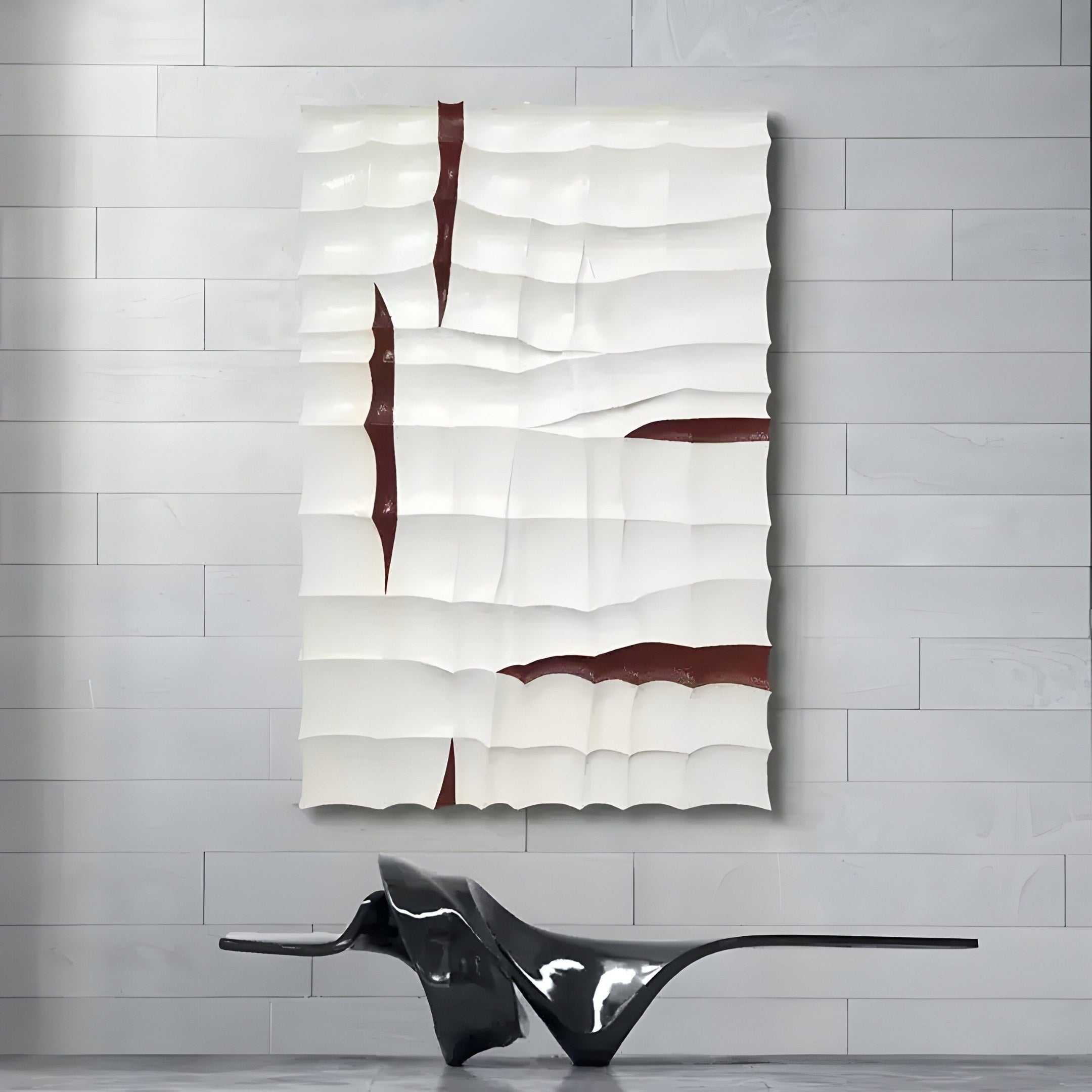 The Striata White & Burgundy Wood Carving 3D Wall Art by Giant Sculptures, featuring wave-like patterns in white and dark red, is mounted on a light gray paneled wall. Below it, an abstract black sculpture adds to the striking visual harmony.