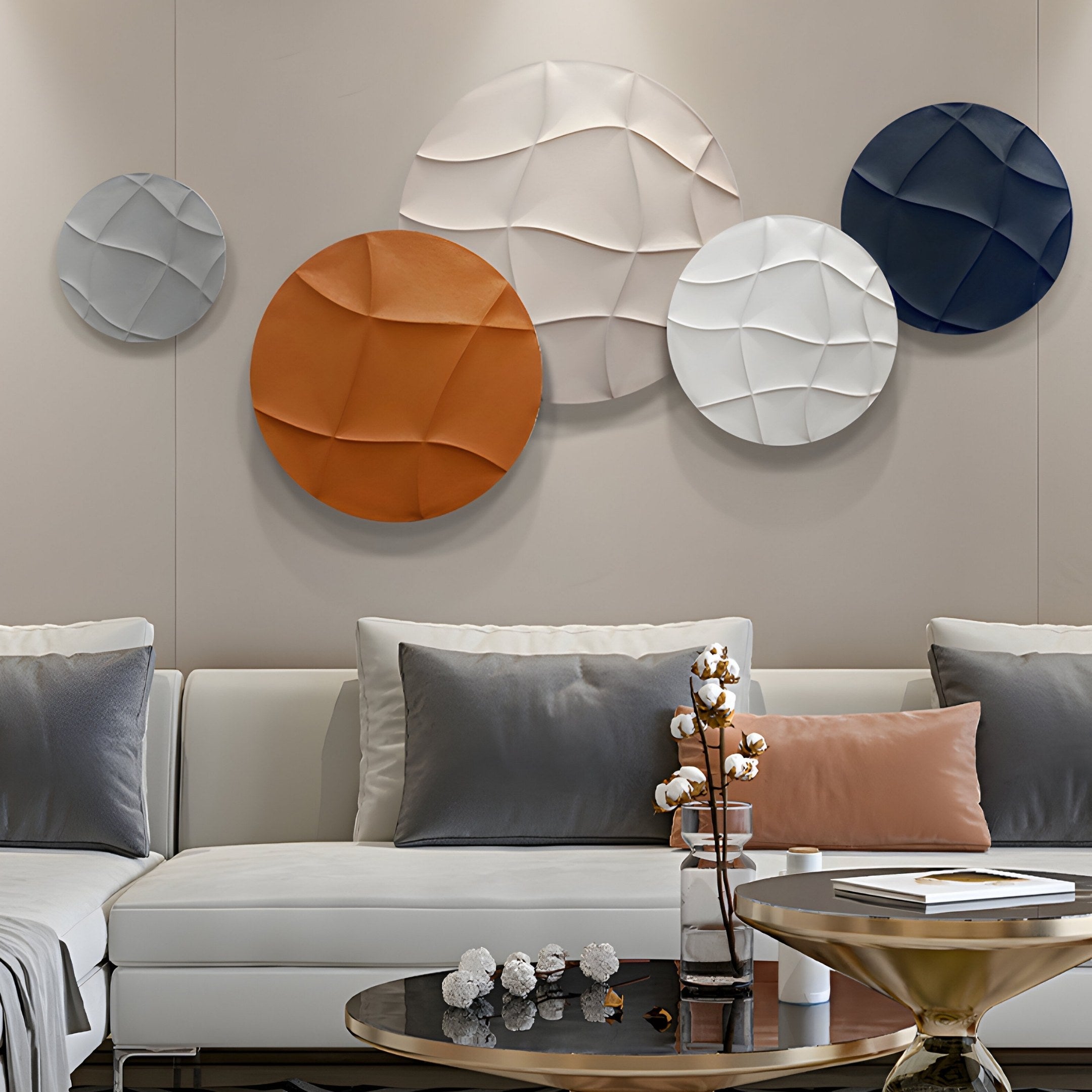 A modern living room features a white sectional sofa with gray and terra-cotta cushions. Above it hangs the Orbura 5-Set Circular Terra & Ivory 3D Wood Relief Wall Art by Giant Sculptures, adding texture in orange, ivory, beige, and blue. A small table with decor completes the scene.
