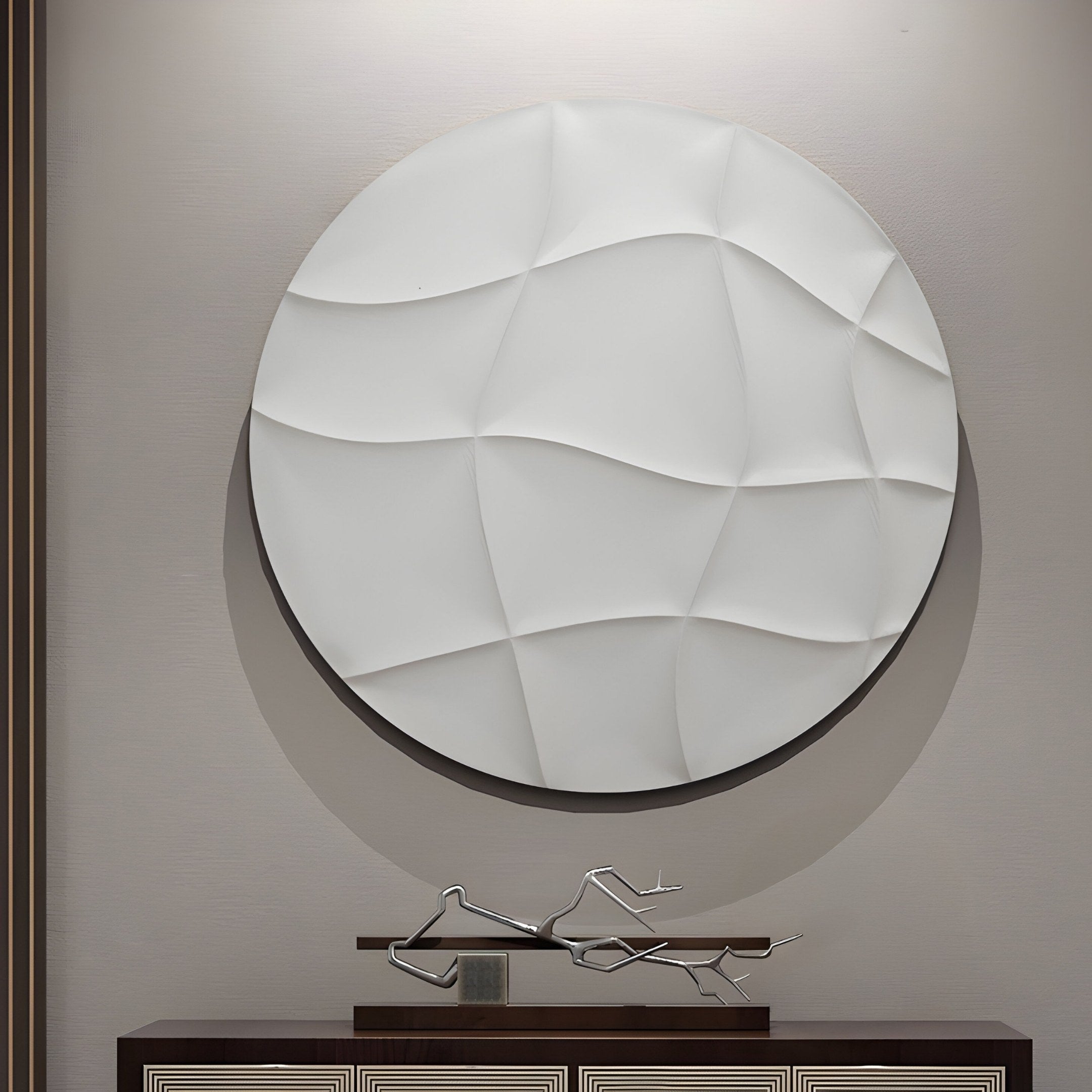 The Orbura White Circular 3D Wood Relief by Giant Sculptures, featuring undulating wave patterns, hangs above a dark minimalist metal sculpture. The abstract shapes of the metal piece complement the reliefs design seamlessly on a light-colored wall.