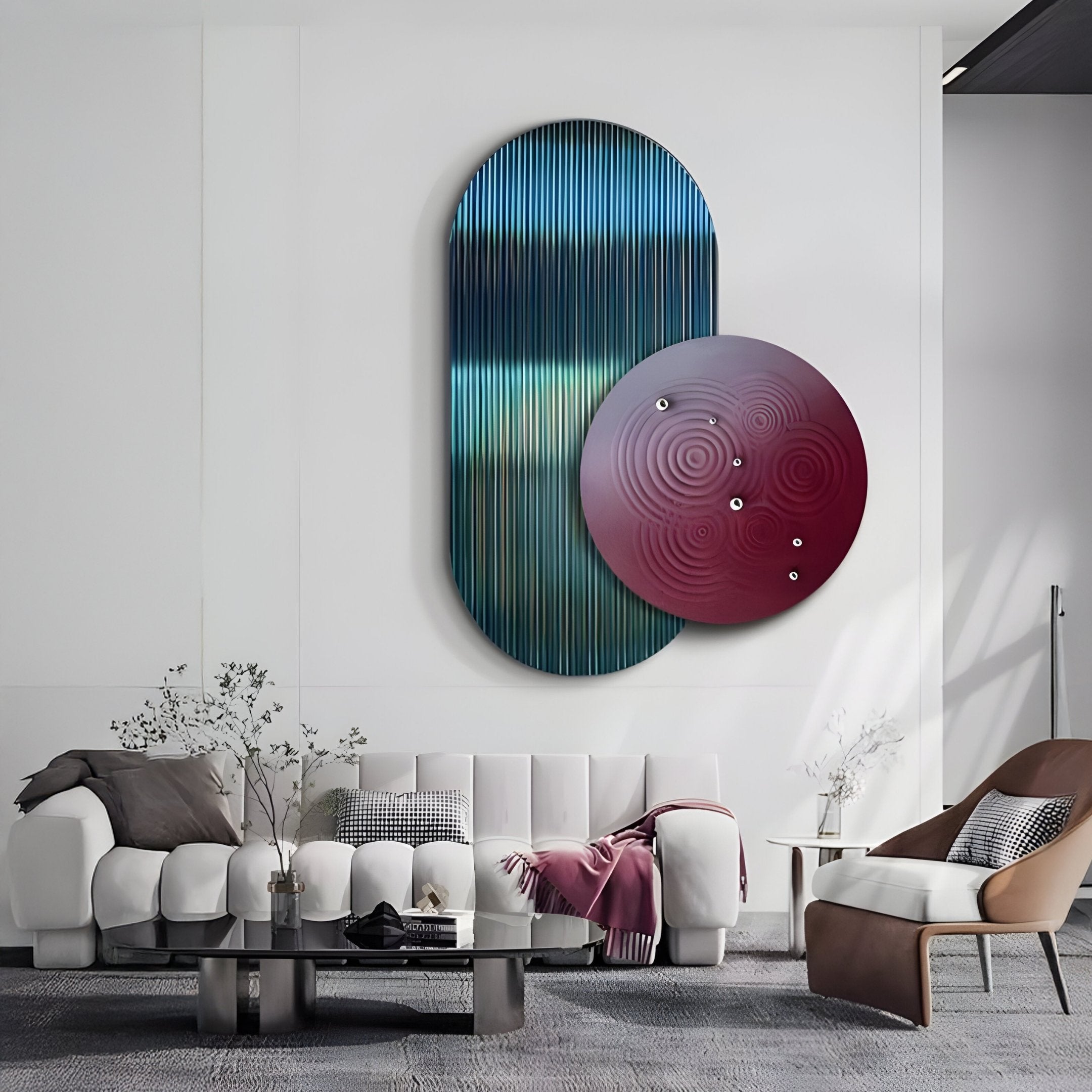 The modern living room features a white sofa, gray coffee table, and brown armchair. The Embera Abstract Circle Navy Warm Gradient 3D Wall Art by Giant Sculptures adds dimension. Minimalist touches like a blanket, pillows, and vases with plants create a cozy atmosphere.