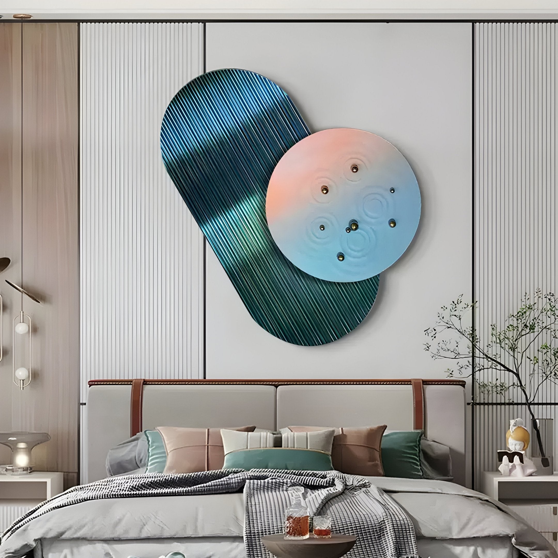 In a modern bedroom, the Embera Abstract Circle Pastel Gradient 3D Wall Art by Giant Sculptures elegantly hangs above the bed, combining a blue oval and circular gradient. The space is adorned with decorative pillows, a small tree to the right, and pendant lights to the left.
