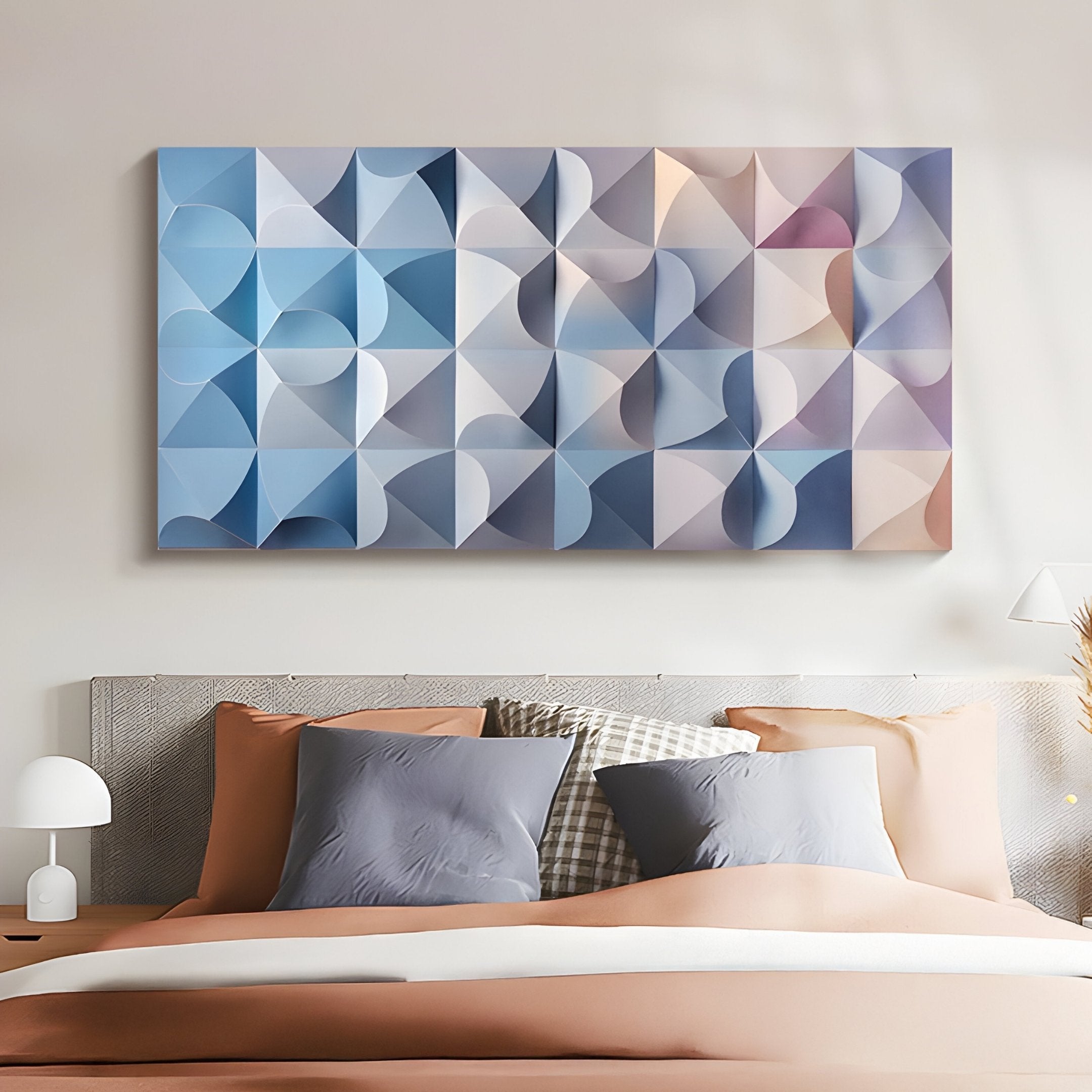 A modern bedroom features a bed with gray and peach pillows. Above, the Elysia Geometric Pastel Gradient 3D Wall Art by Giant Sculptures reflects blue, gray, and peach tones. To the left, a small white lamp elegantly rests on the bedside table.
