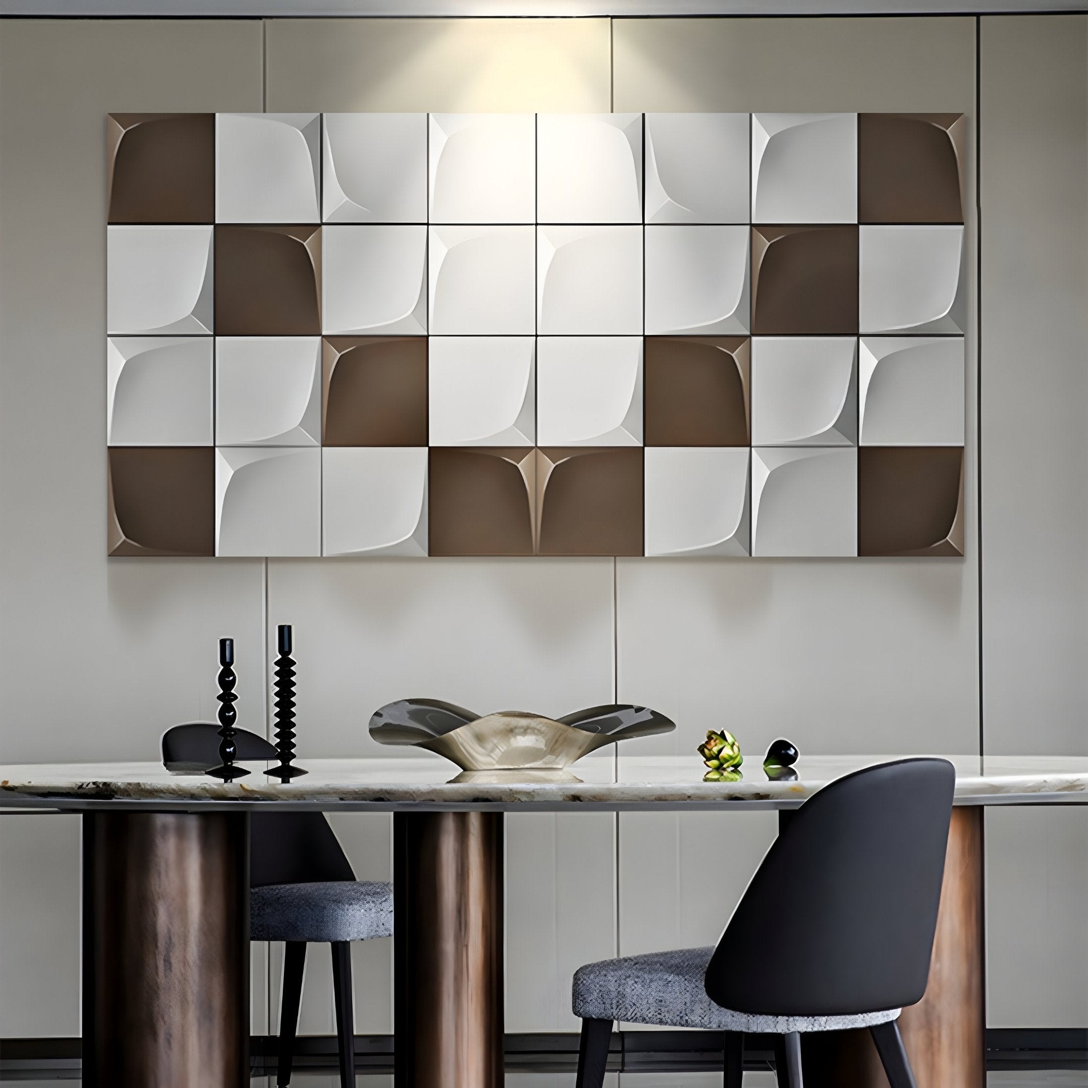 The modern dining area showcases the Averra White & Brown Geometric Wood Relief 3D Wall Art by Giant Sculptures above a sleek table. The table features sculptural black candle holders, a glass centerpiece, and green accents. Two chairs on either side enhance the spaces modern geometry.