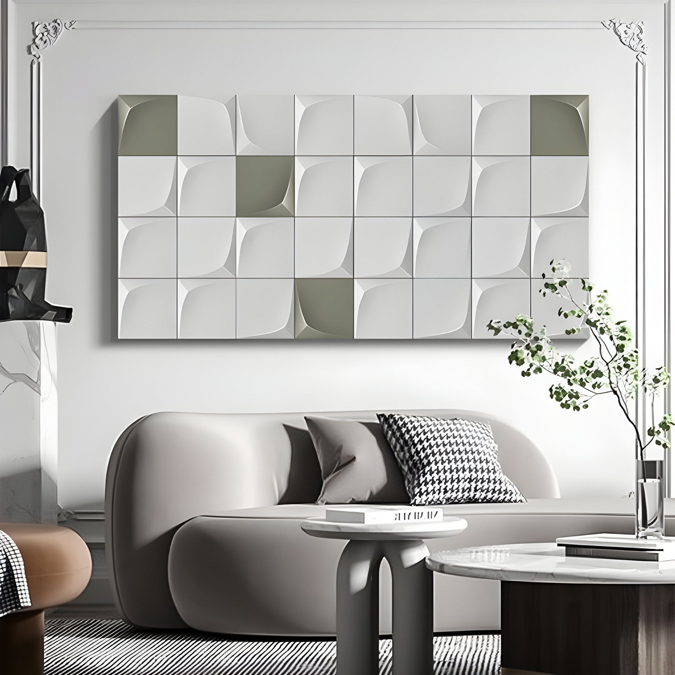 A modern living room includes a gray sofa, a small round coffee table, and a black-and-white patterned cushion. The Averra White & Sage Grid Block Wood Relief 3D Wall Art by Giant Sculptures adds depth above the sofa, while a plant to the right brings in greenery.