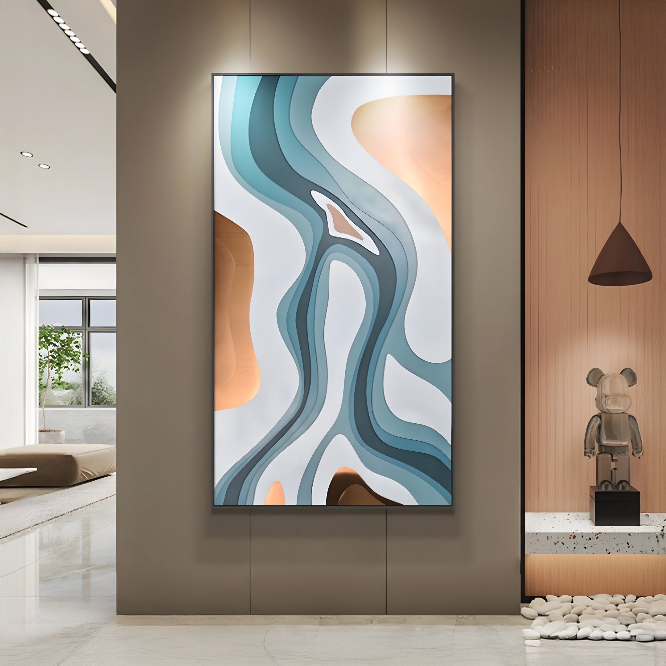 The modern room features the Marea Organic Flow Aqua & Copper Wood Relief 3D Wall Art by Giant Sculptures. It has flowing blue and tan shapes, a small sculpture, pendant light, minimalistic decor with neutral tones, and a windowed area revealing greenery outside.