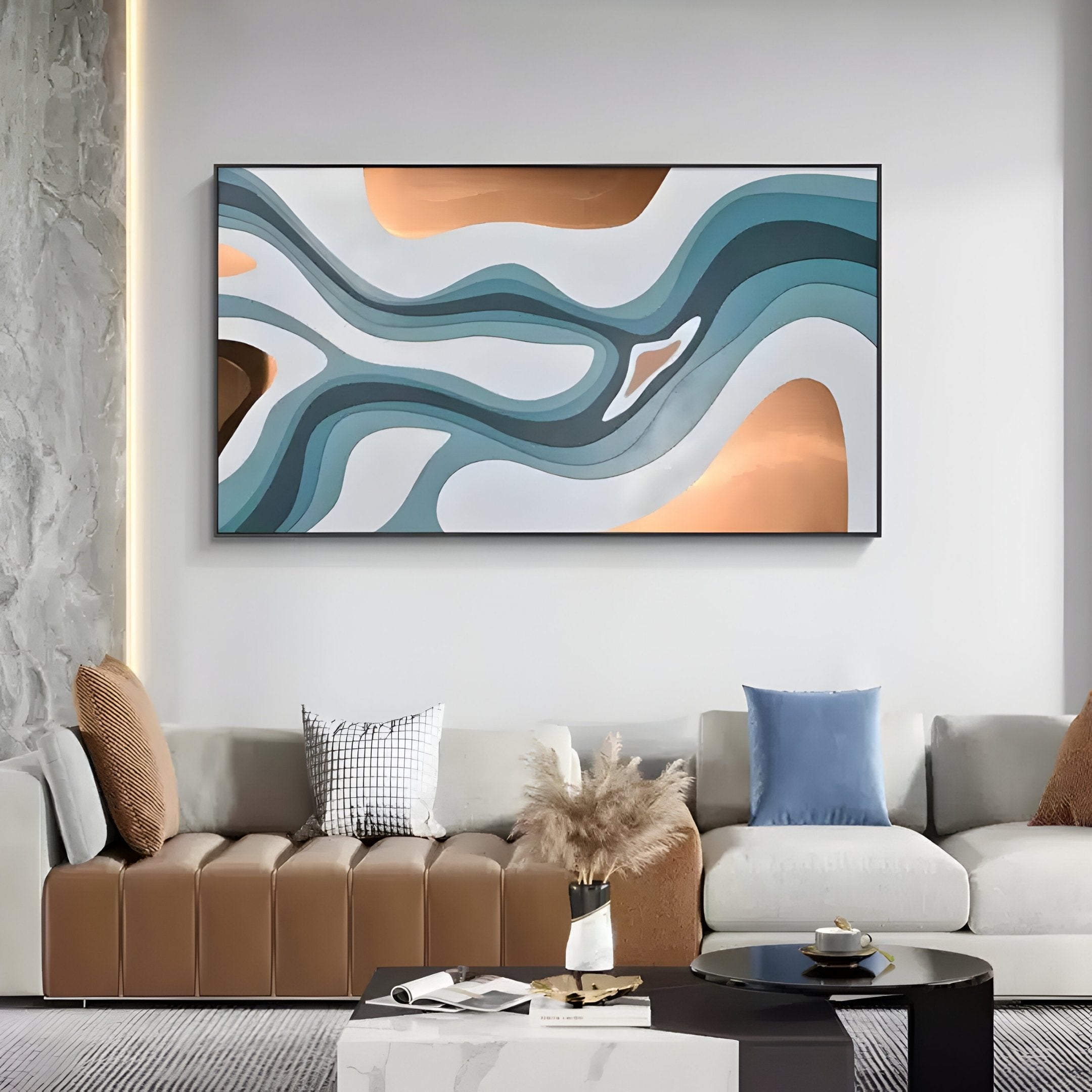 A modern living room features a beige and brown sectional sofa with assorted cushions. A Giant Sculptures Marea Organic Flow Aqua & Copper Wood Relief 3D Wall Art decorates the wall, showcasing wavy blue and brown shapes. A round black coffee table with decor items sits centrally.