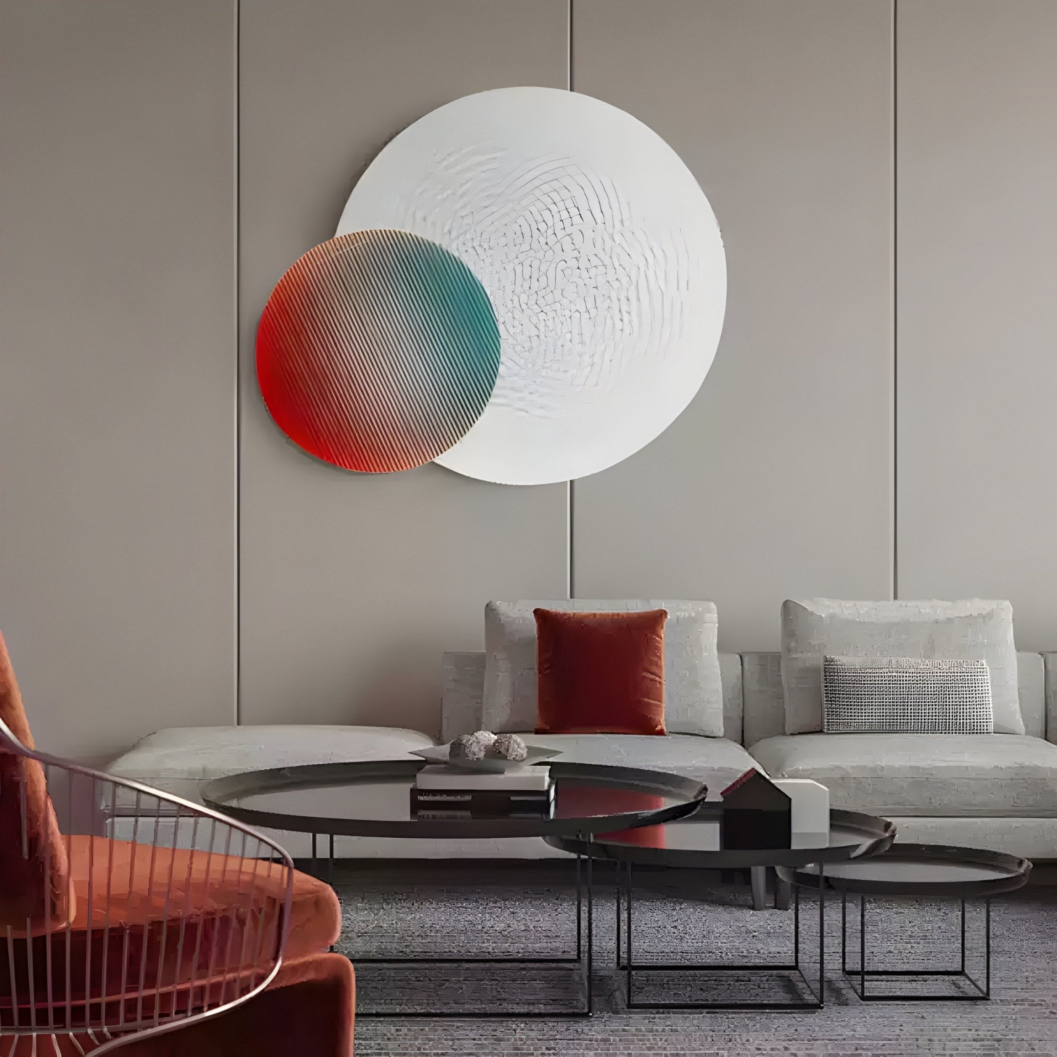 A modern living room highlights a gray sectional sofa with orange cushions, paired with nesting coffee tables. The Lucentis Wall Art by Giant Sculptures adds a dynamic touch with its 3D relief and overlapping circles in white, red, and teal, creating a stylish minimalist decor.
