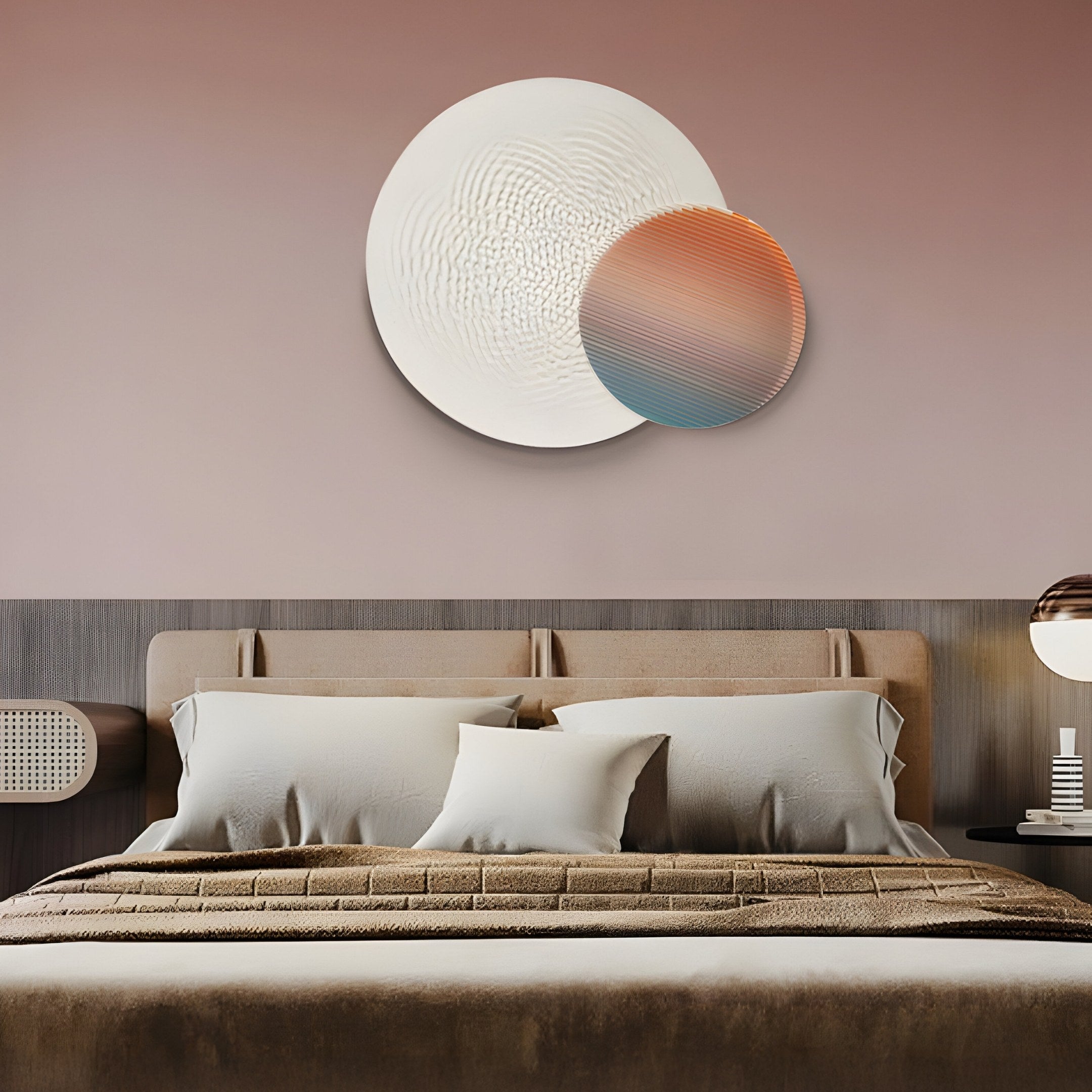 A modern bedroom showcases a beige upholstered bed, pillows, and a textured duvet. On the wall are two overlapping circular art pieces from Giant Sculptures: Lucentis White & Sunset Gradient 3D Wood Relief Wall Art. A lamp on a side table complements the soothing decor.