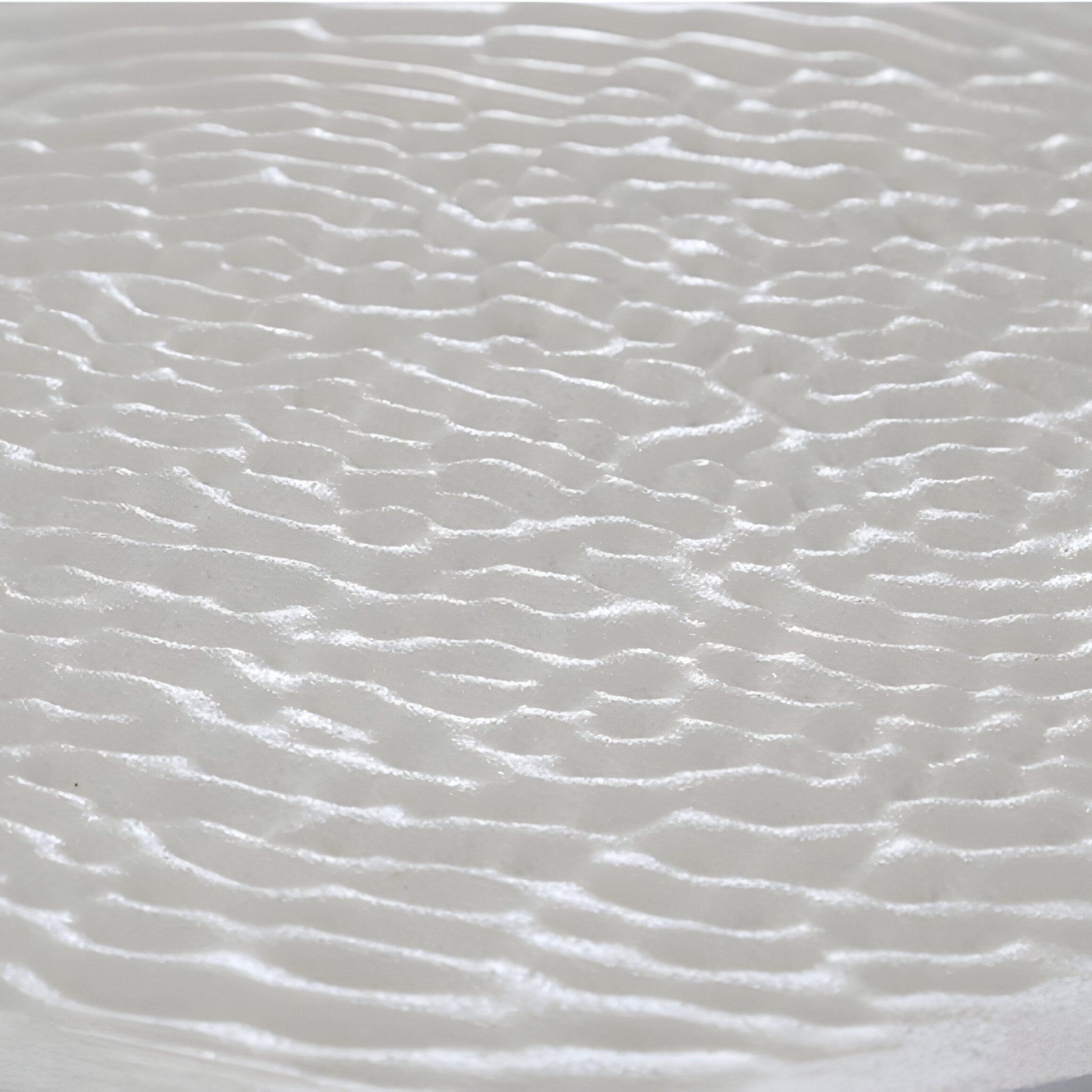 Close-up of a textured surface with a wavy, shiny look. Giant Sculptures Lucentis White & Teal Gradient Wood Relief 3D Wall Art showcases smooth ripples, evoking movement and fluidity.